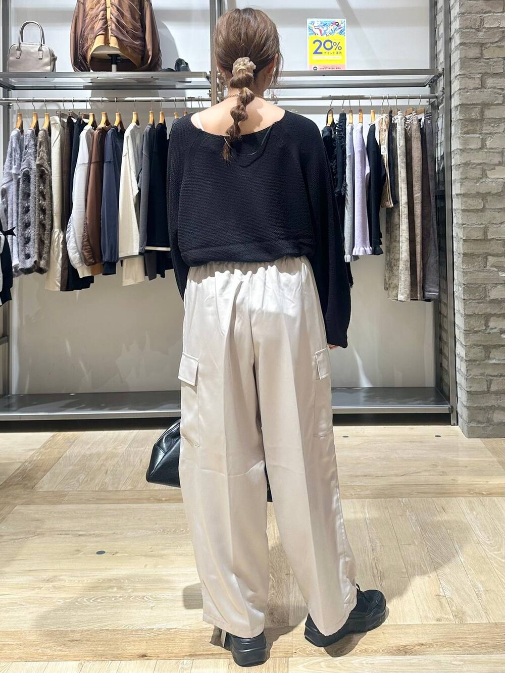 ブラック系のニット/セーター、ブラック系のスニーカー、ホワイト系のその他パンツを着用したレディースの秋コーディネートの4枚目の写真