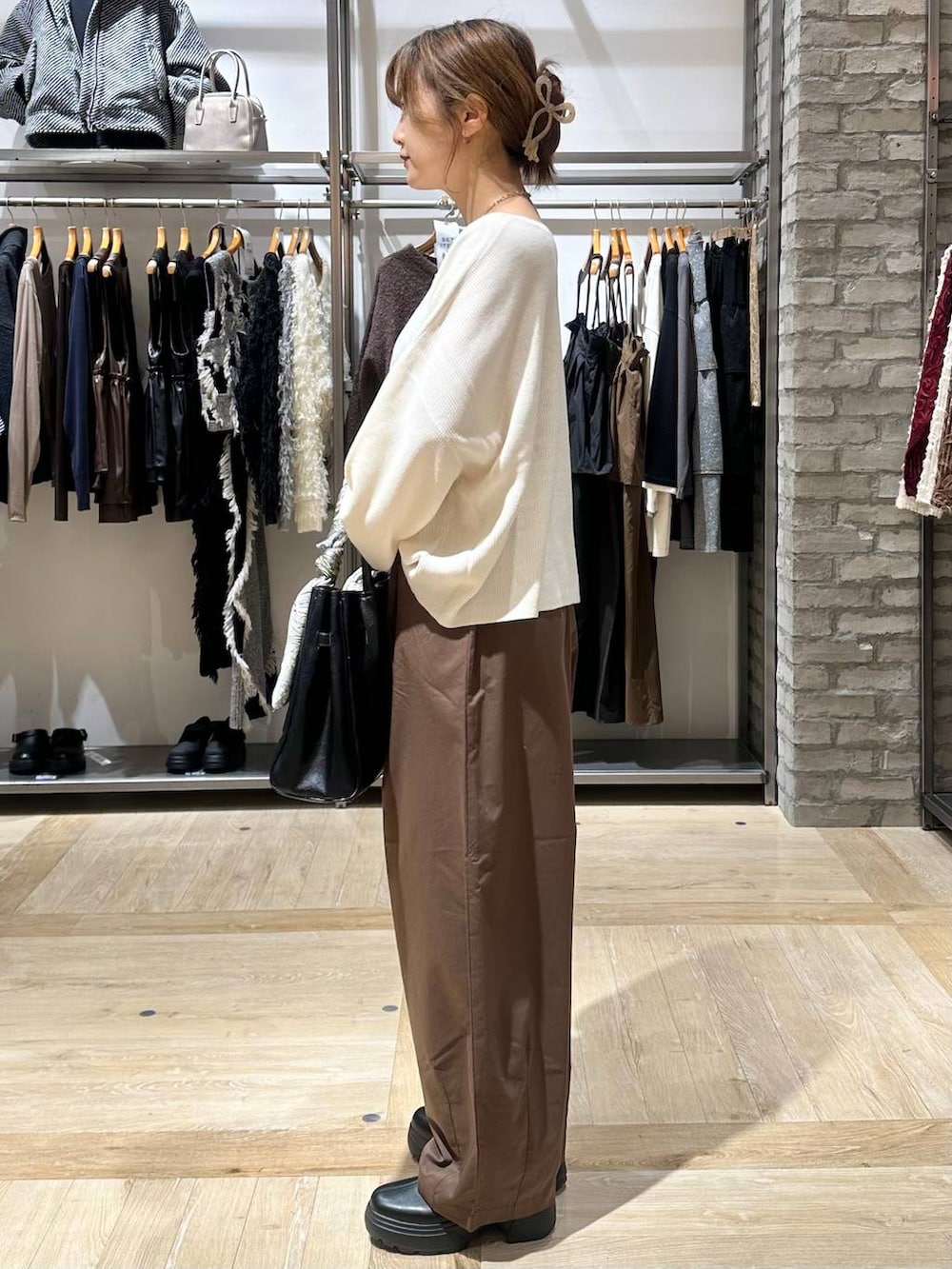 ホワイト系のニット/セーター、ブラック系のショルダーバッグ、ブラウン系のその他パンツを着用したレディースの秋コーディネートの6枚目の写真