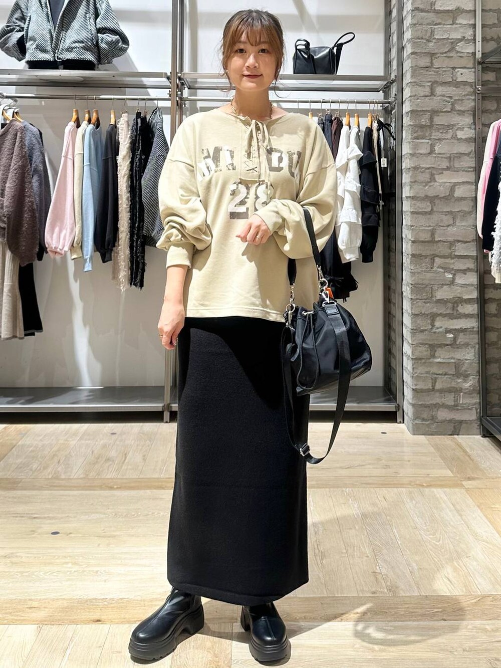 ブラック系のショルダーバッグ、ブラック系のスカート、ホワイト系のその他アウターを着用したレディースの秋コーディネートの2枚目の写真