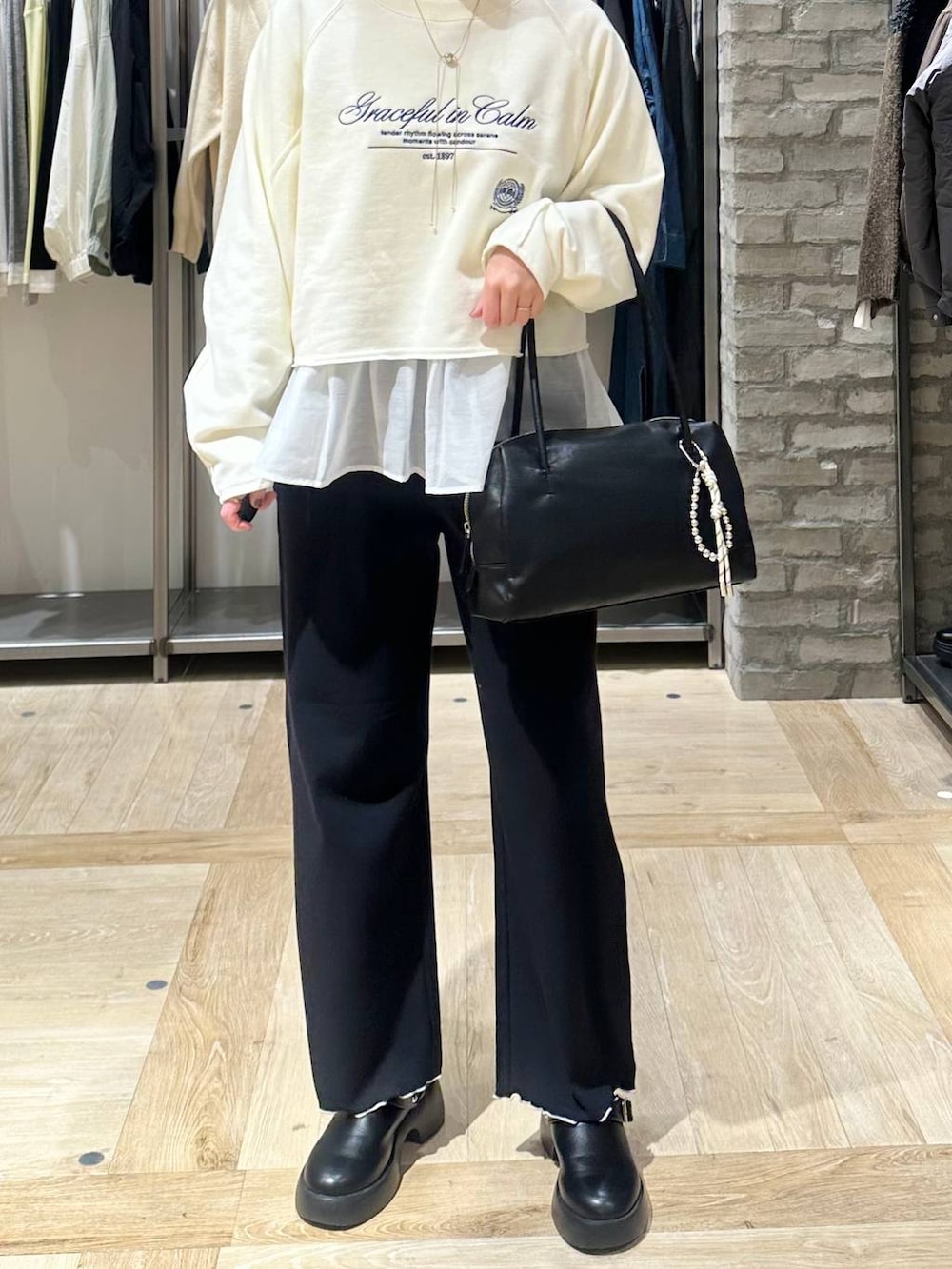 ブラック系のサンダル、ホワイト系のTシャツ/カットソー、ブラック系のボストンバッグを着用したレディースの冬コーディネートの5枚目の写真