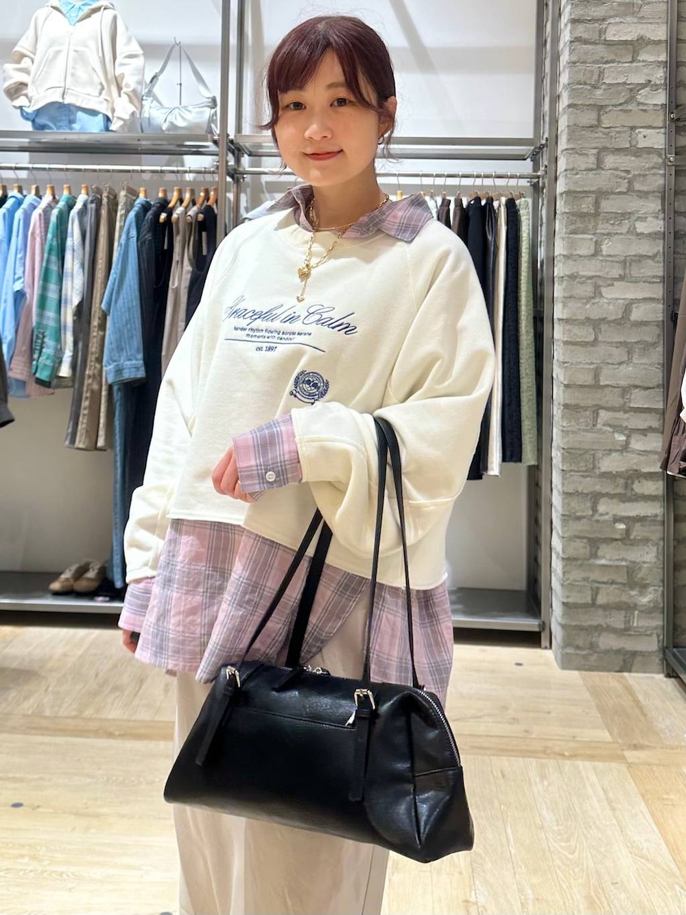 ブラック系のボストンバッグ、ベージュ系のスカート、ホワイト系のスウェットを着用したレディースの春コーディネートの4枚目の写真