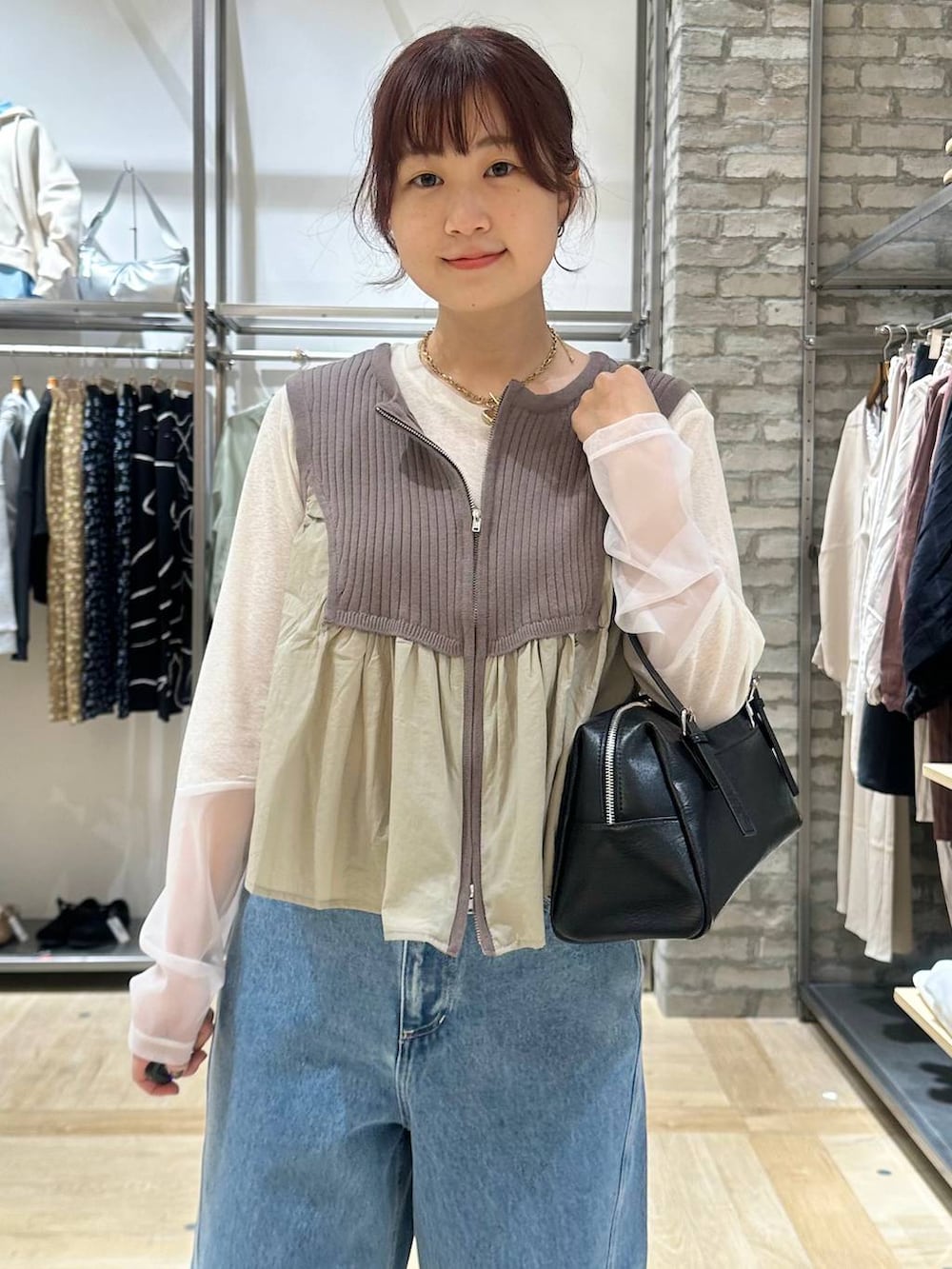 ホワイト系のTシャツ/カットソー、ブラック系のボストンバッグ、ブルー系のデニムパンツを着用したレディースの春コーディネートの4枚目の写真