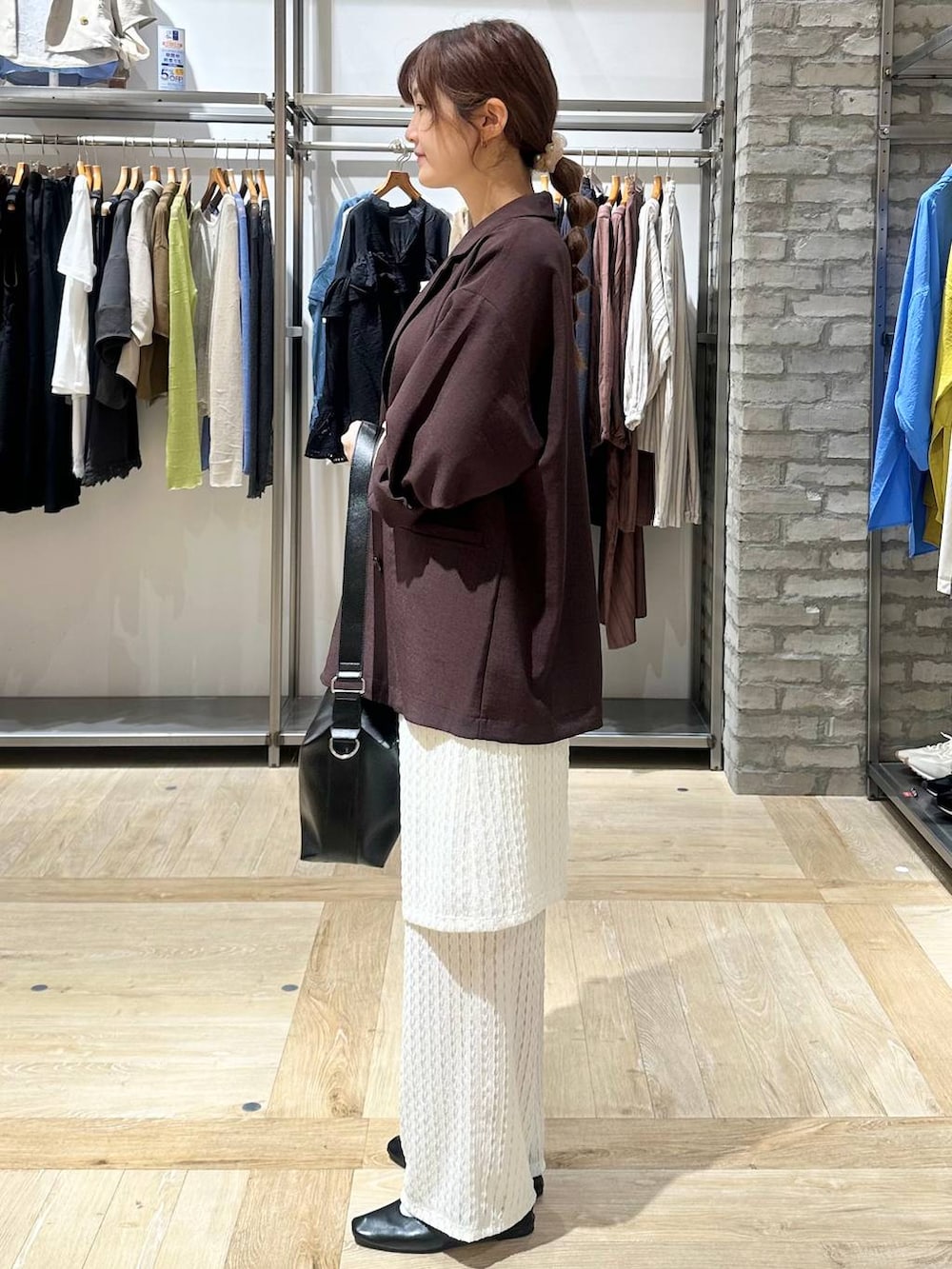 ブラック系のショルダーバッグ、ブラック系のパンプス、ブラウン系のテーラードジャケットを着用したレディースの春コーディネートの2枚目の写真