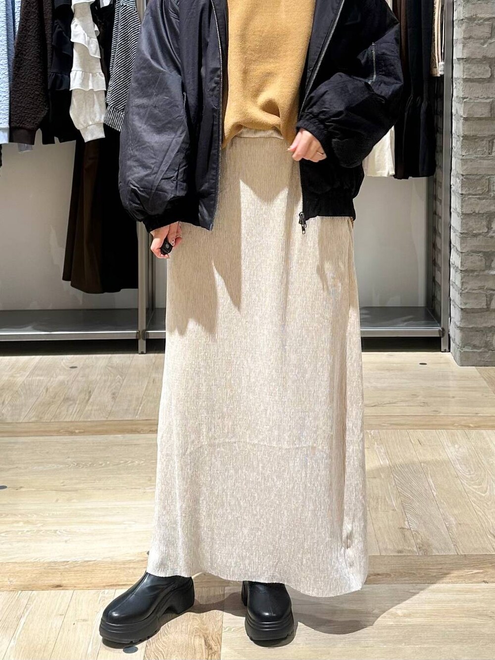 イエロー系のニット/セーター、ブラック系のボストンバッグ、ブラック系のブーツを着用したレディースの秋コーディネートの5枚目の写真