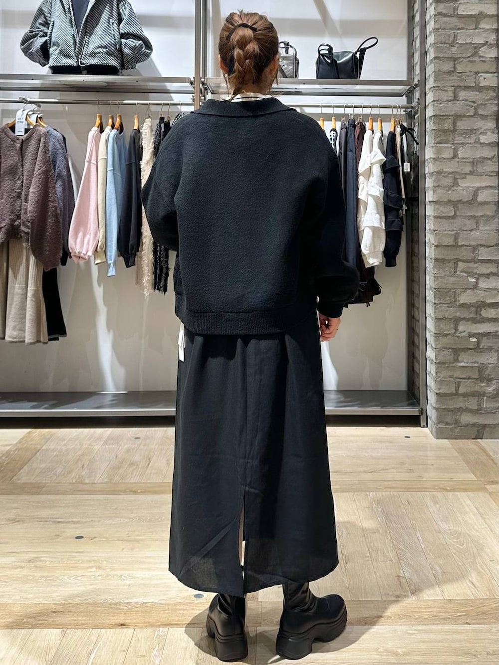 ブラック系のショルダーバッグ、ホワイト系のニット/セーター、ブラック系のブーツを着用したレディースの秋コーディネートの4枚目の写真