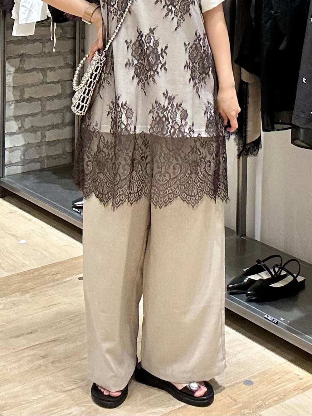 ベージュ系のその他パンツ、ブラック系のサンダル、シルバー系のショルダーバッグを着用したレディースの春コーディネートの5枚目の写真