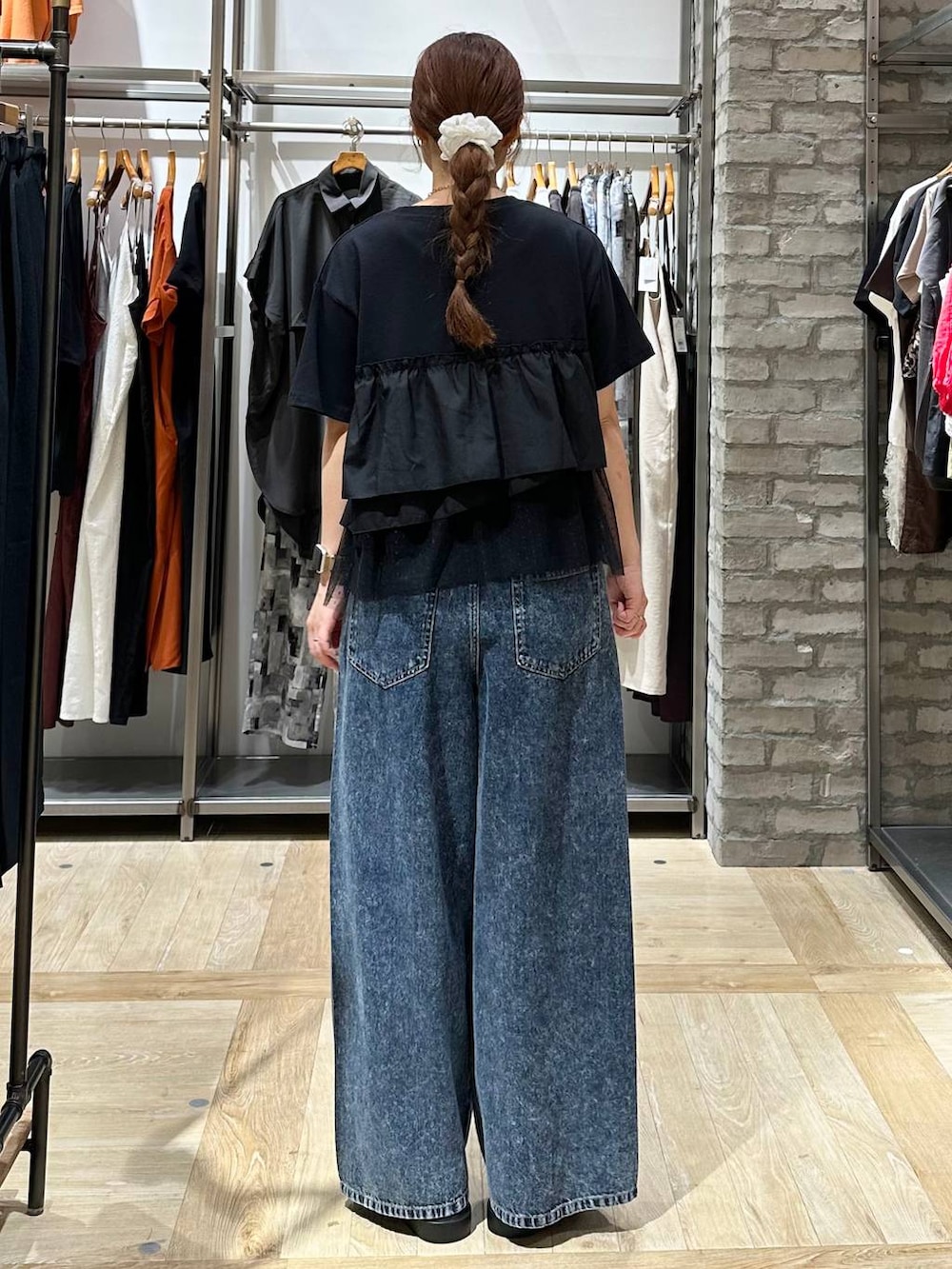 ブルー系のデニムパンツ、ブラック系のサンダル、ブラック系のTシャツ/カットソーを着用したレディースの夏コーディネートの3枚目の写真