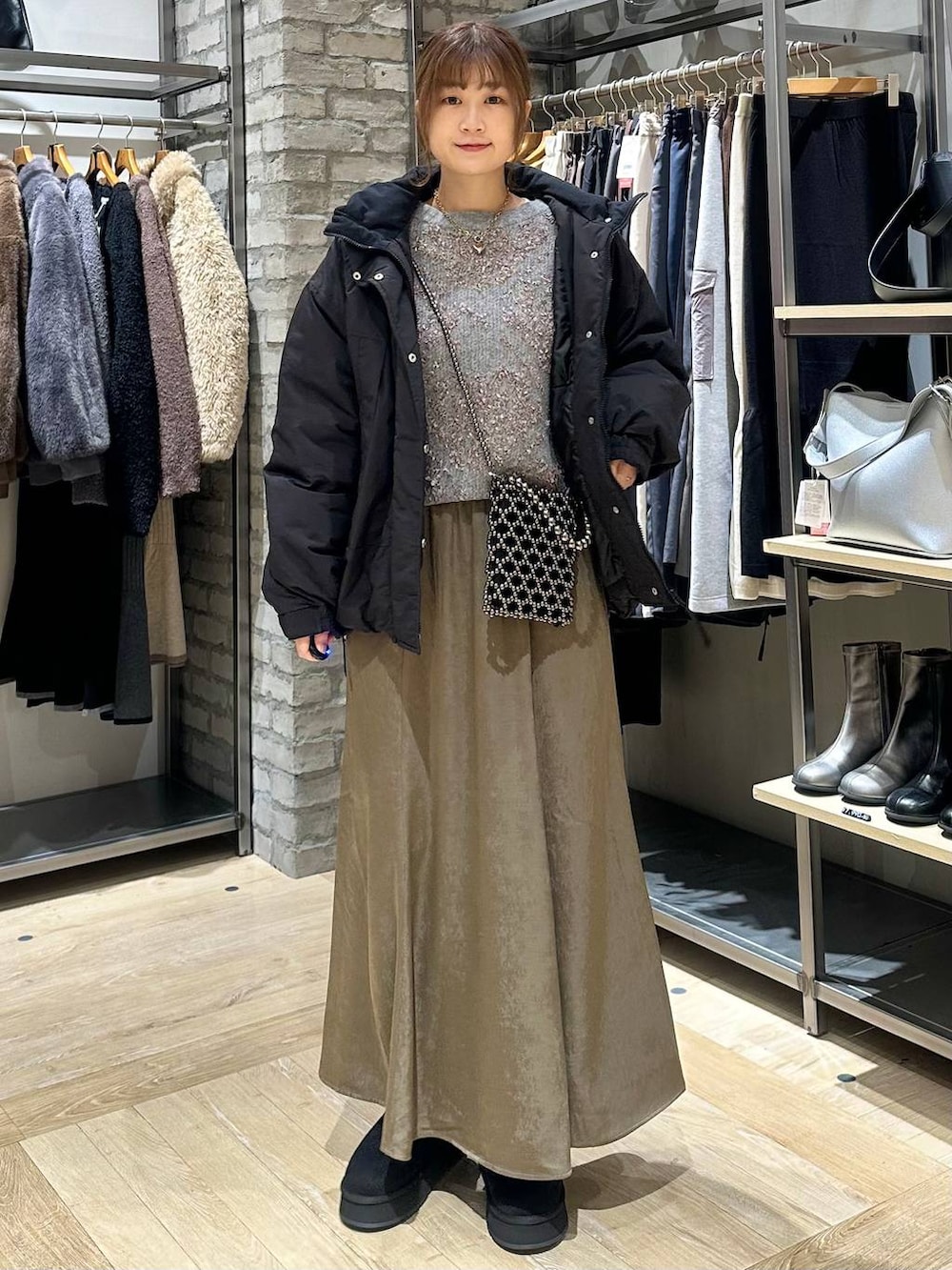 ブラック系のショルダーバッグ、ブラック系のその他アウター、ブラウン系のスカートを着用したレディースの秋コーディネートの4枚目の写真