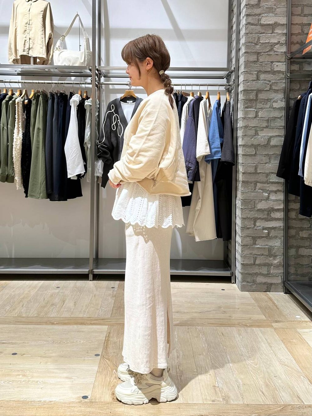 ホワイト系のTシャツ/カットソー、ホワイト系のスカート、ホワイト系のスニーカーを着用したレディースの春コーディネートの2枚目の写真