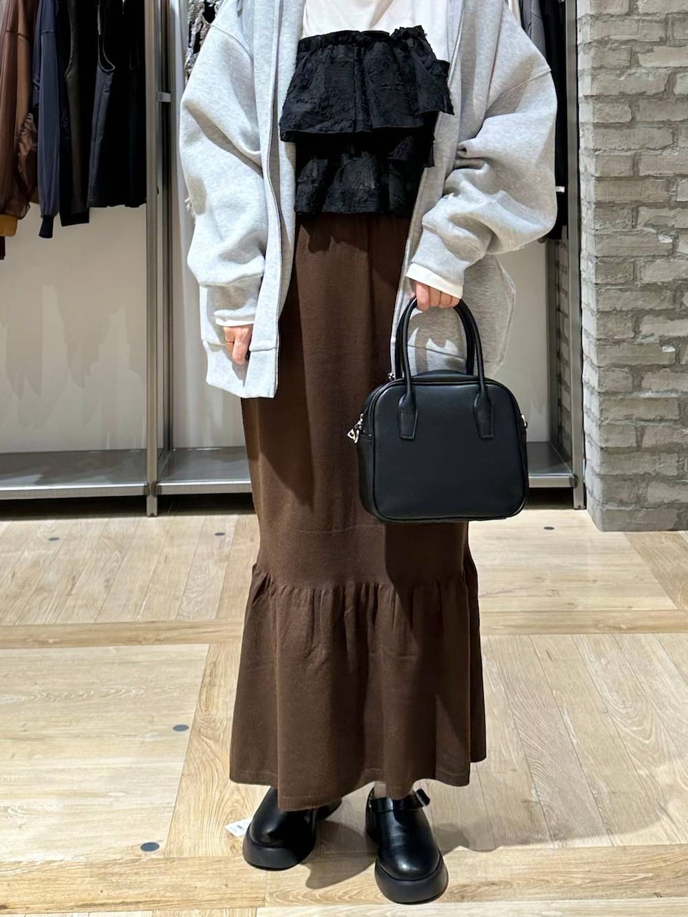 ブラウン系のスカート、ホワイト系のTシャツ/カットソー、ブラック系のサンダルを着用したレディースの秋コーディネートの6枚目の写真