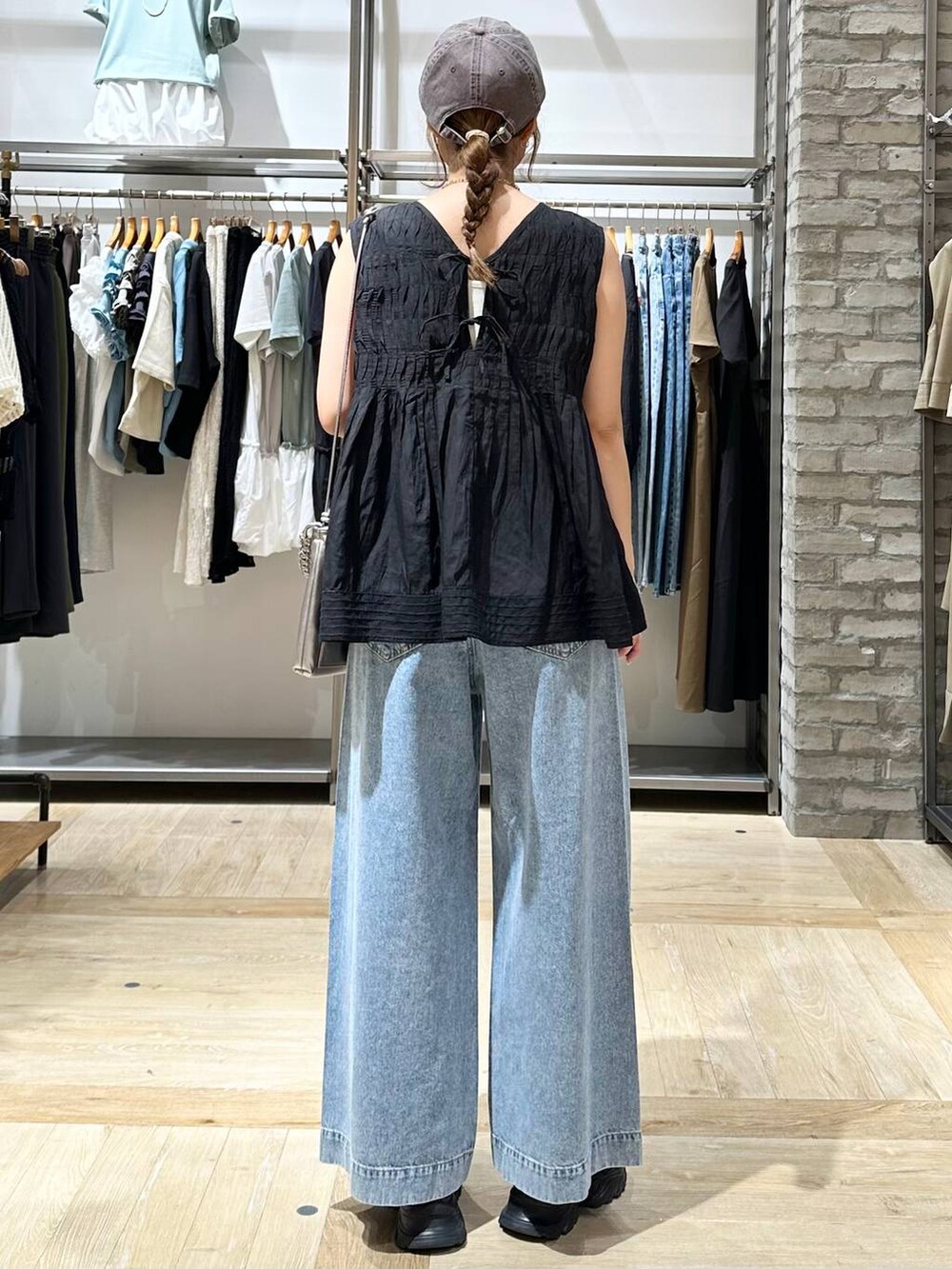 ブラック系のシャツ/ブラウス、ブラック系のサンダル、ブルー系のデニムパンツを着用したレディースの夏コーディネートの4枚目の写真