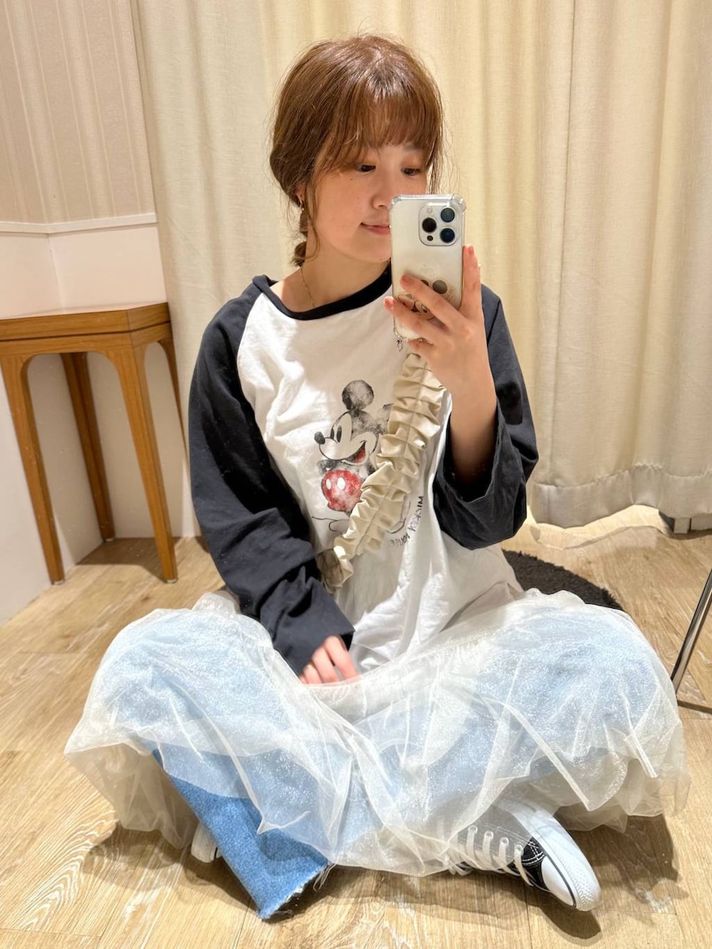 ホワイト系のスカート、ブラック系のTシャツ/カットソー、ブルー系のデニムパンツを着用したレディースの春コーディネートの6枚目の写真
