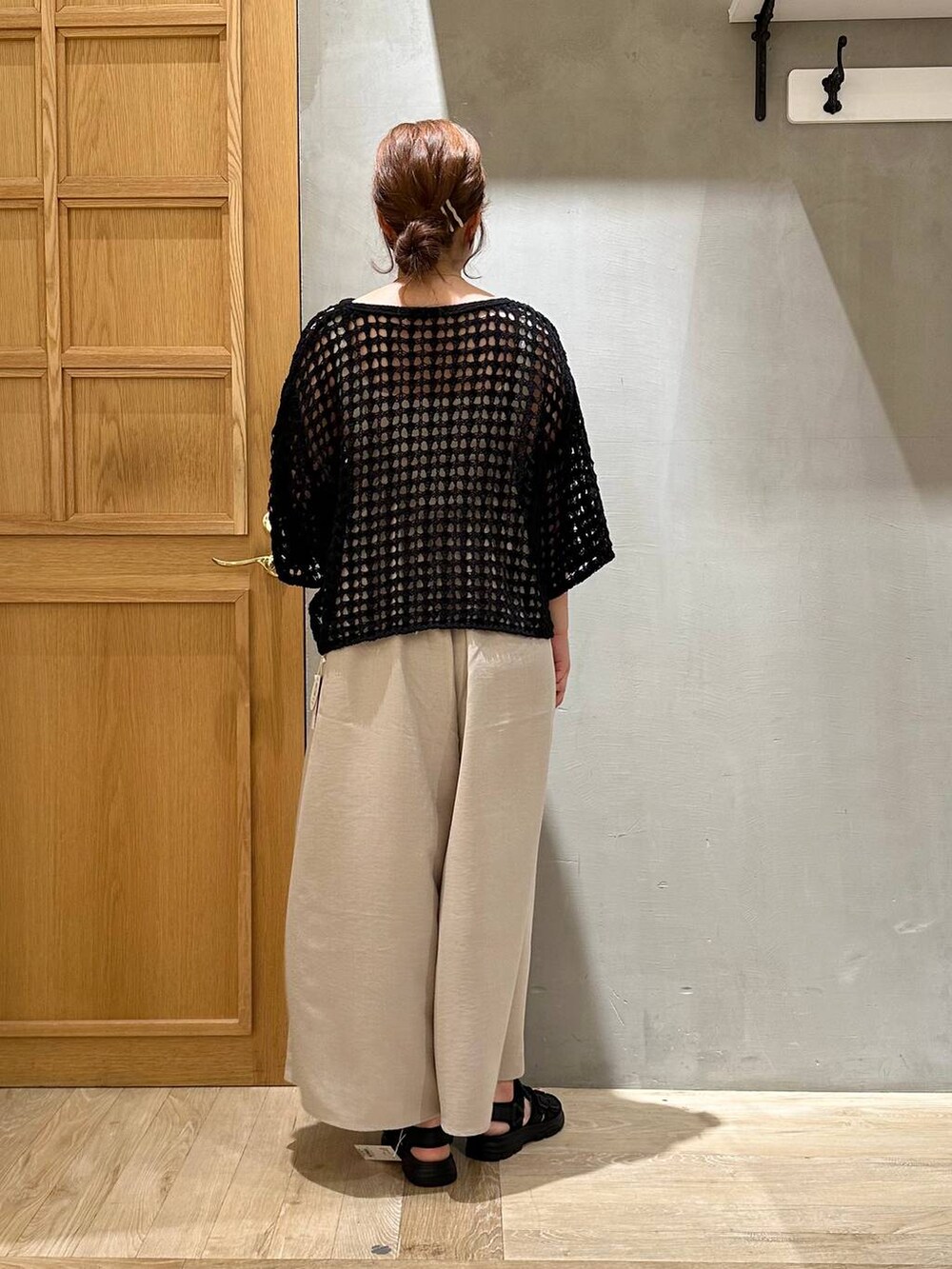 ベージュ系のその他パンツ、ブラック系のニット/セーター、ブラック系のサンダルを着用したレディースの春コーディネートの4枚目の写真