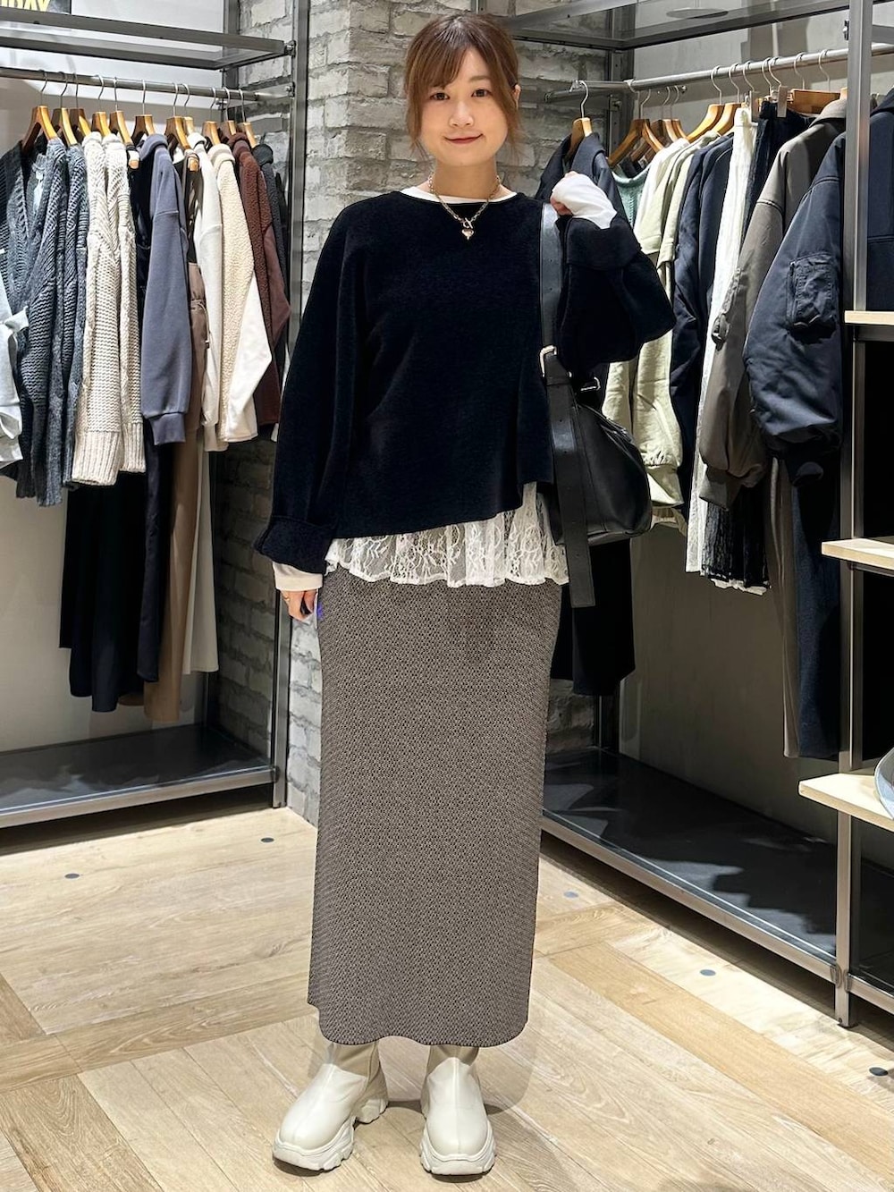 ホワイト系のブーツ、ブラック系のスカート、ブラック系のその他アウターを着用したレディースの冬コーディネートの5枚目の写真