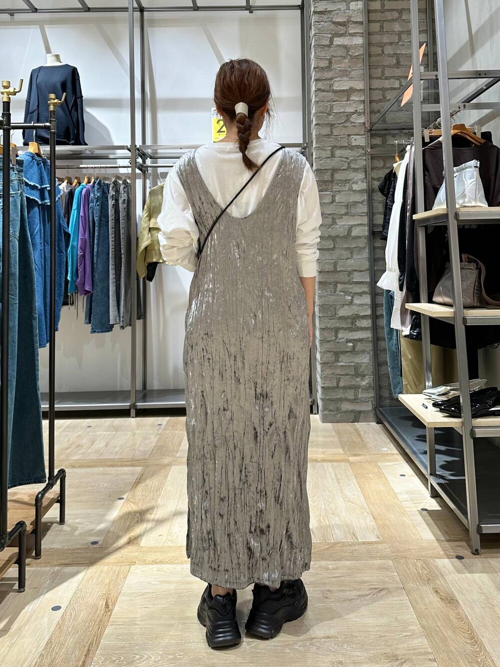 ブラック系のスニーカー、ブラック系のショルダーバッグ、ホワイト系のTシャツ/カットソーを着用したレディースの秋コーディネートの3枚目の写真
