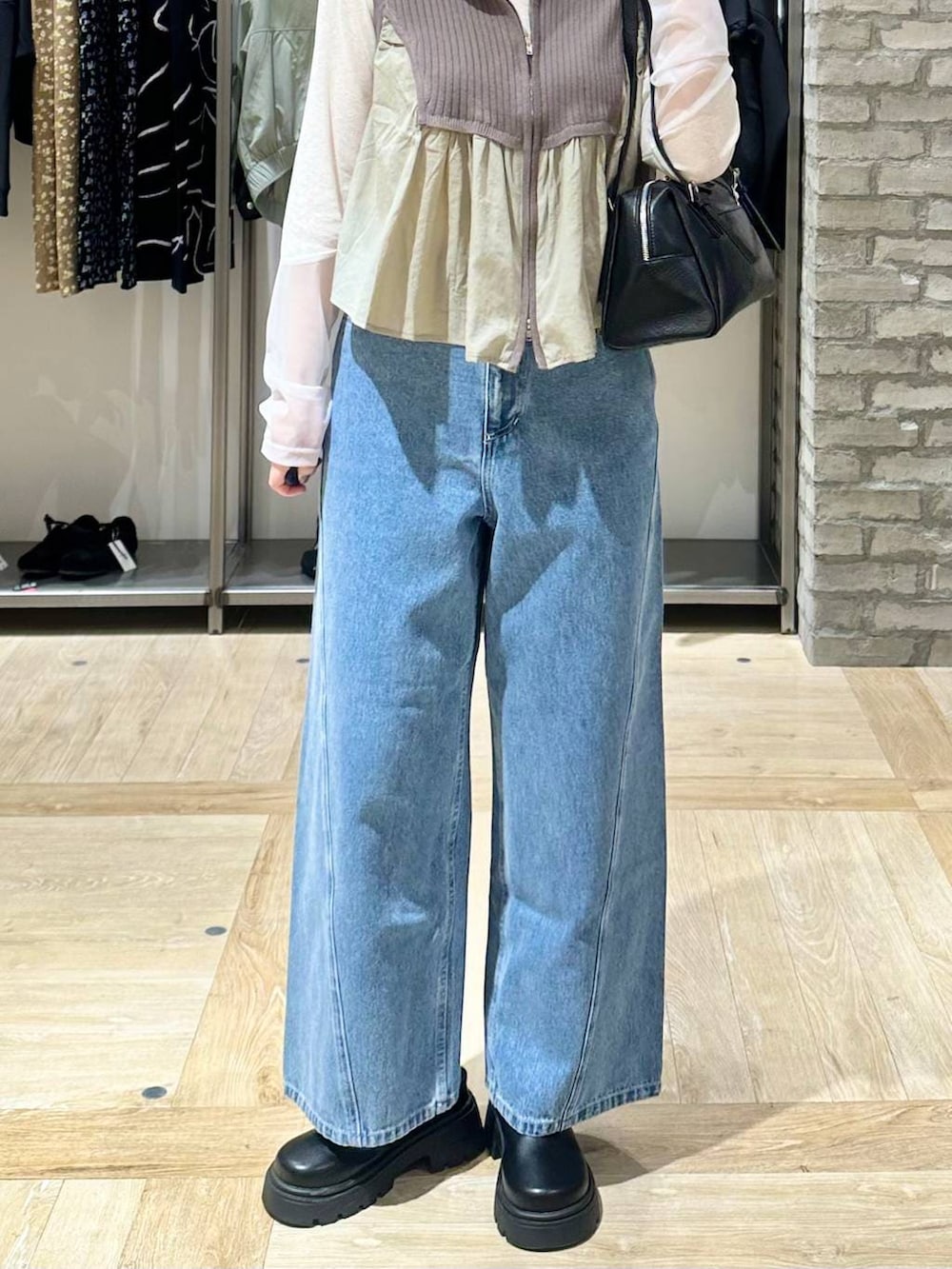 ホワイト系のTシャツ/カットソー、ブラック系のボストンバッグ、ブルー系のデニムパンツを着用したレディースの春コーディネートの5枚目の写真