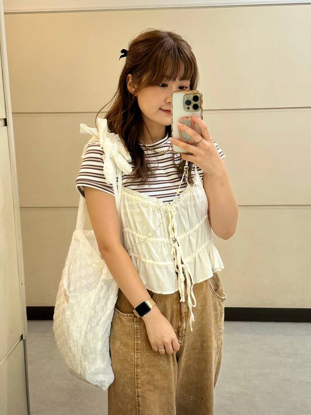 ホワイト系のトートバッグ、ホワイト系のキャミソールを着用したレディースの夏コーディネートの2枚目の写真