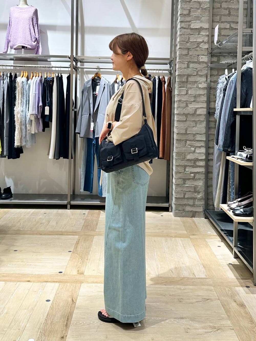 イエロー系のタンクトップ、ベージュ系のシャツ/ブラウス、ブラック系のショルダーバッグを着用したレディースの春コーディネートの2枚目の写真