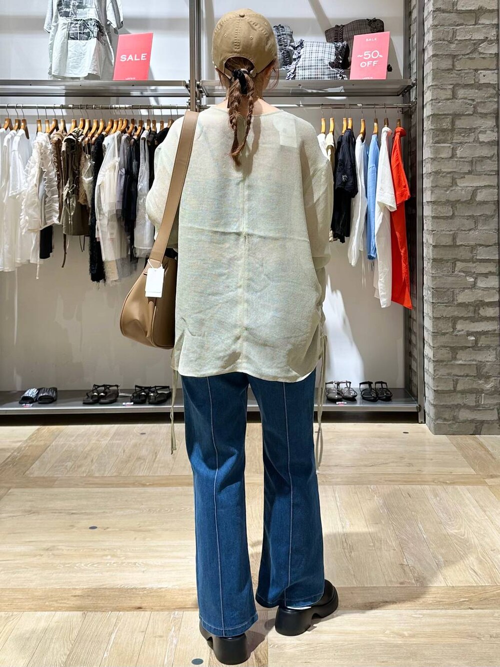 ベージュ系のショルダーバッグ、ブルー系のその他パンツ、ブラック系のサンダルを着用したレディースの秋コーディネートの3枚目の写真