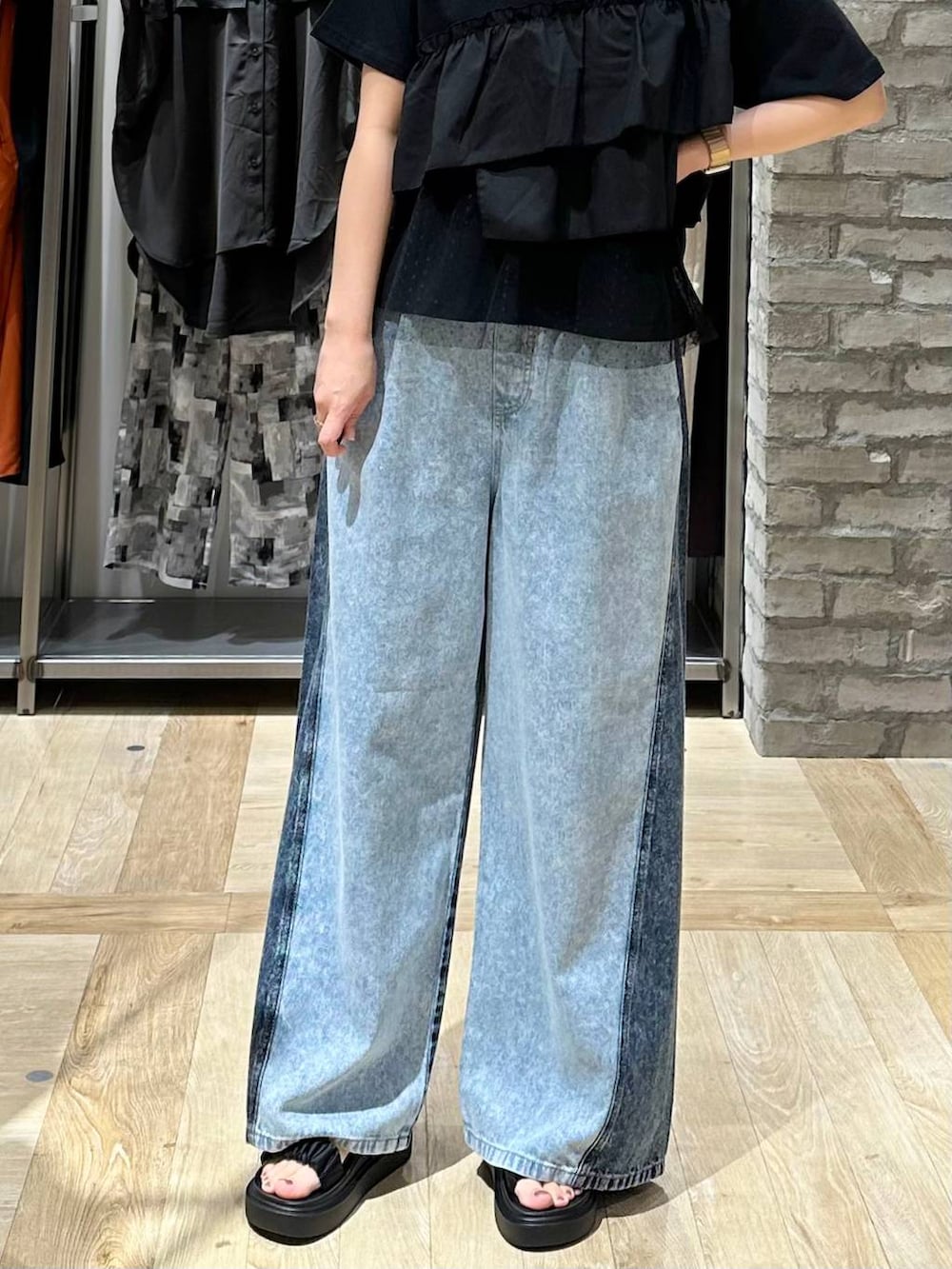 ブルー系のデニムパンツ、ブラック系のサンダル、ブラック系のTシャツ/カットソーを着用したレディースの夏コーディネートの5枚目の写真