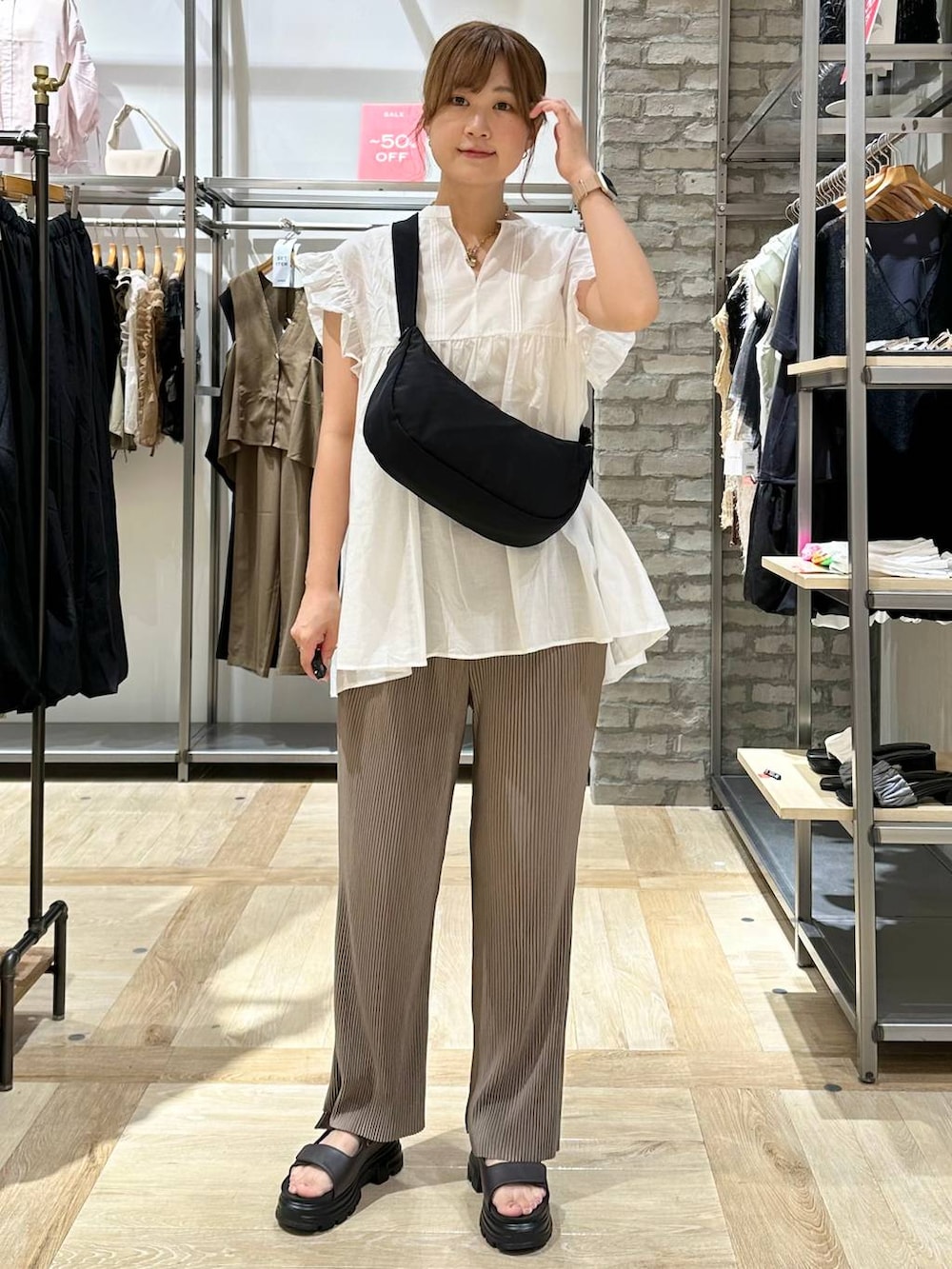 ブラウン系のその他パンツ、ブラック系のショルダーバッグ、ブラウン系のサンダルを着用したレディースの夏コーディネートの2枚目の写真
