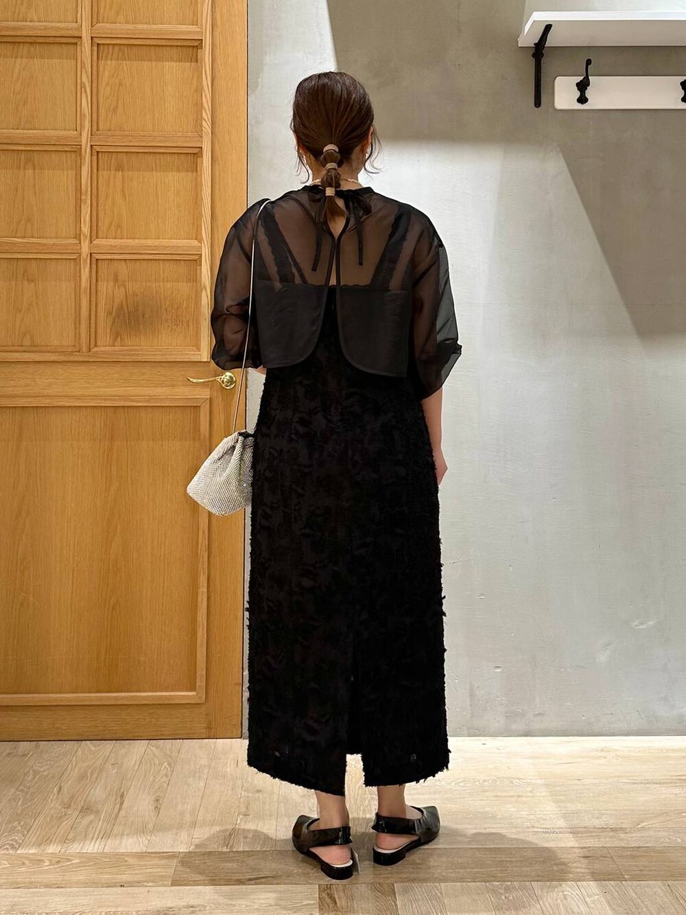 シルバー系のショルダーバッグ、ブラック系のその他シューズ、ブラック系のドレスを着用したレディースの秋コーディネートの3枚目の写真