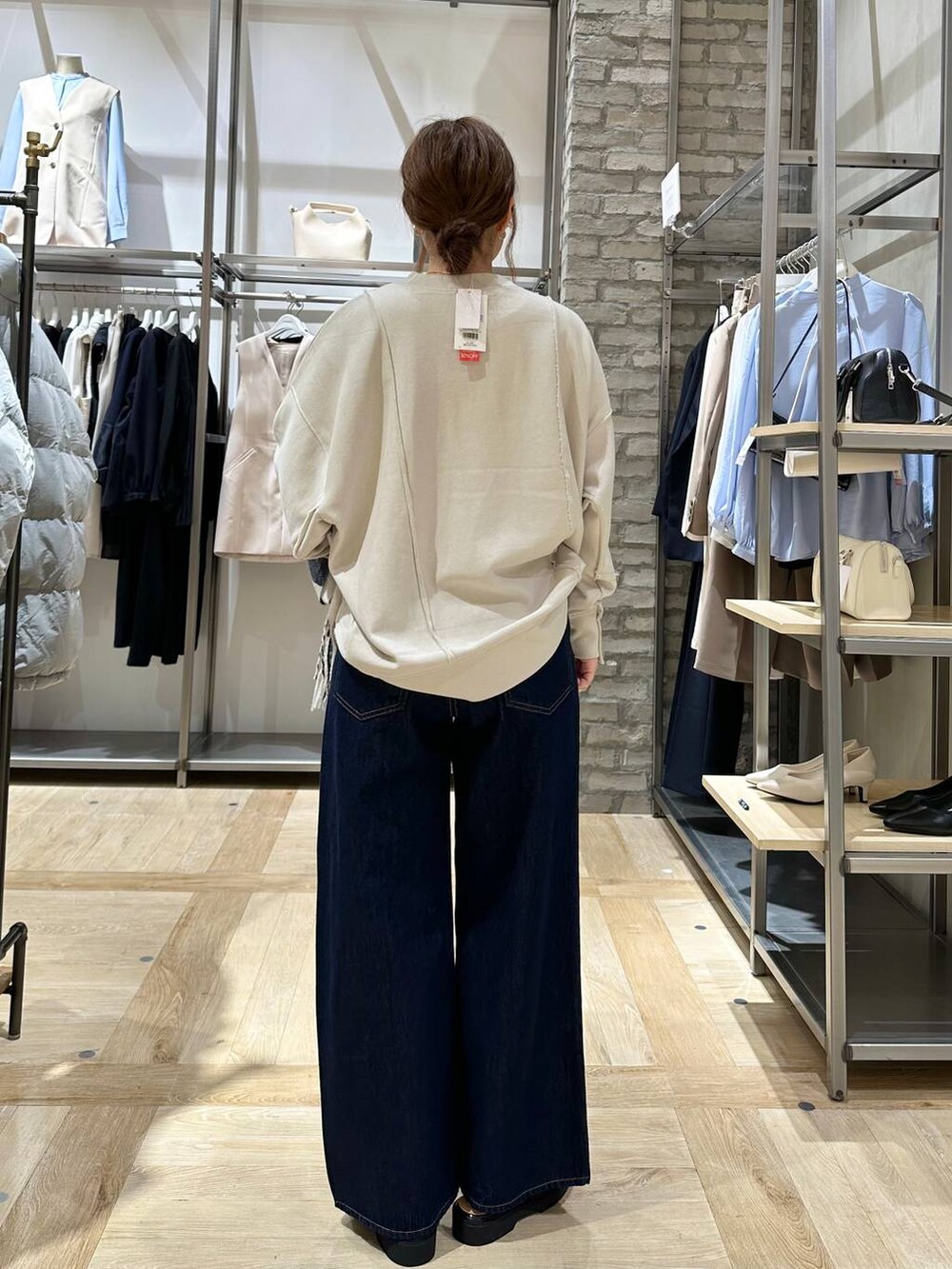 ベージュ系のスウェット、ブラウン系のローファー、ブルー系のデニムパンツを着用したレディースの冬コーディネートの3枚目の写真