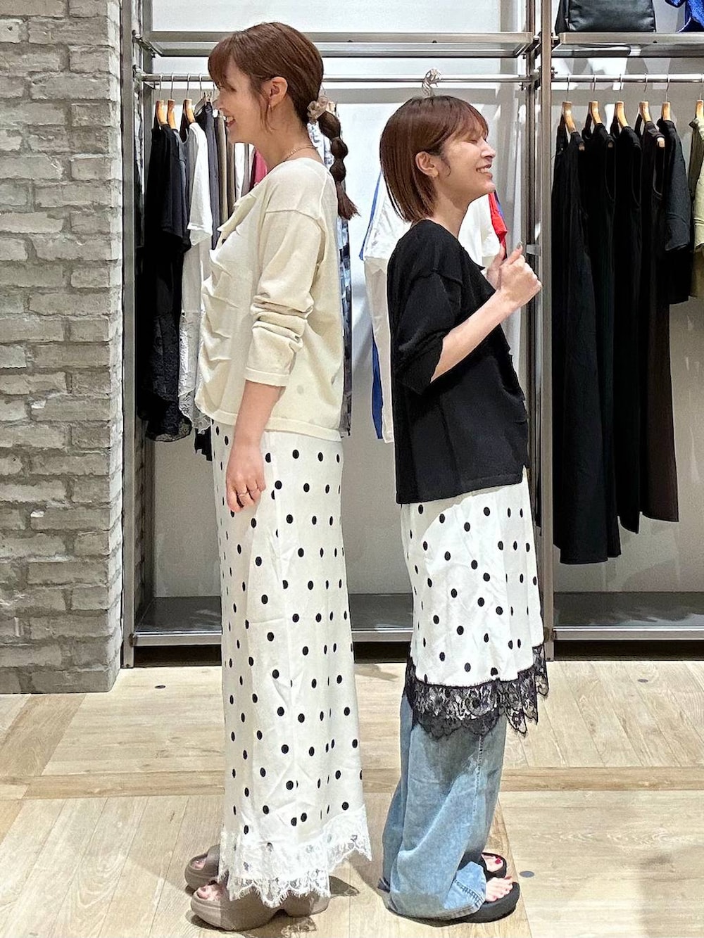 ブルー系のデニムパンツ、ブラウン系のタンクトップ、ベージュ系のサンダルを着用したレディースの夏コーディネートの2枚目の写真