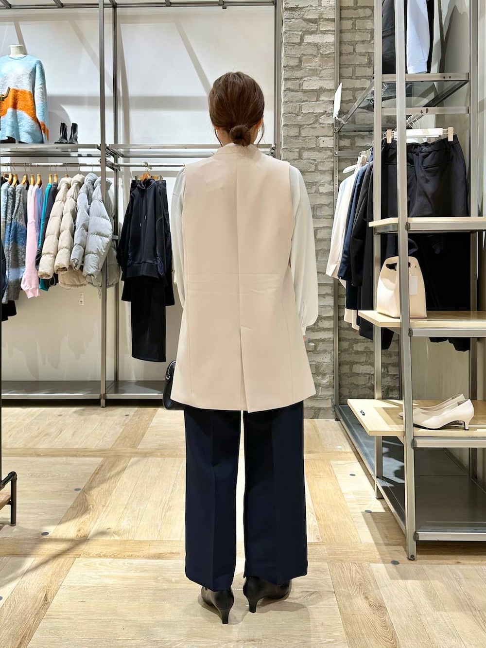 ブルー系のスーツパンツ、ホワイト系のシャツ/ブラウス、ベージュ系のスーツベストを着用したレディースの冬コーディネートの3枚目の写真