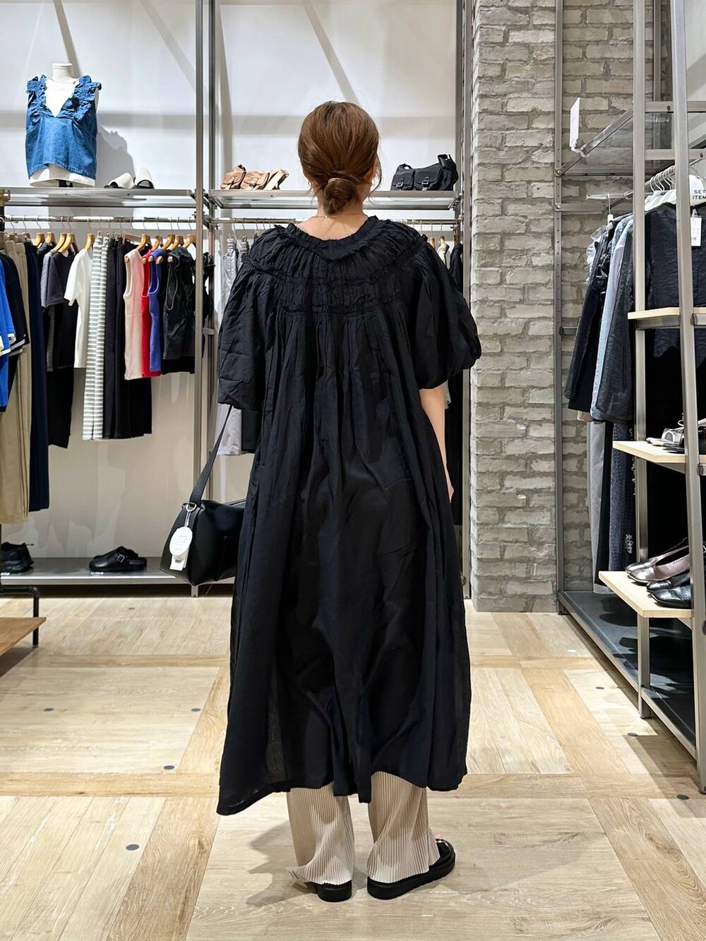 ブラック系のショルダーバッグ、ブラック系のワンピース、ブラック系のサンダルを着用したレディースの春コーディネートの3枚目の写真