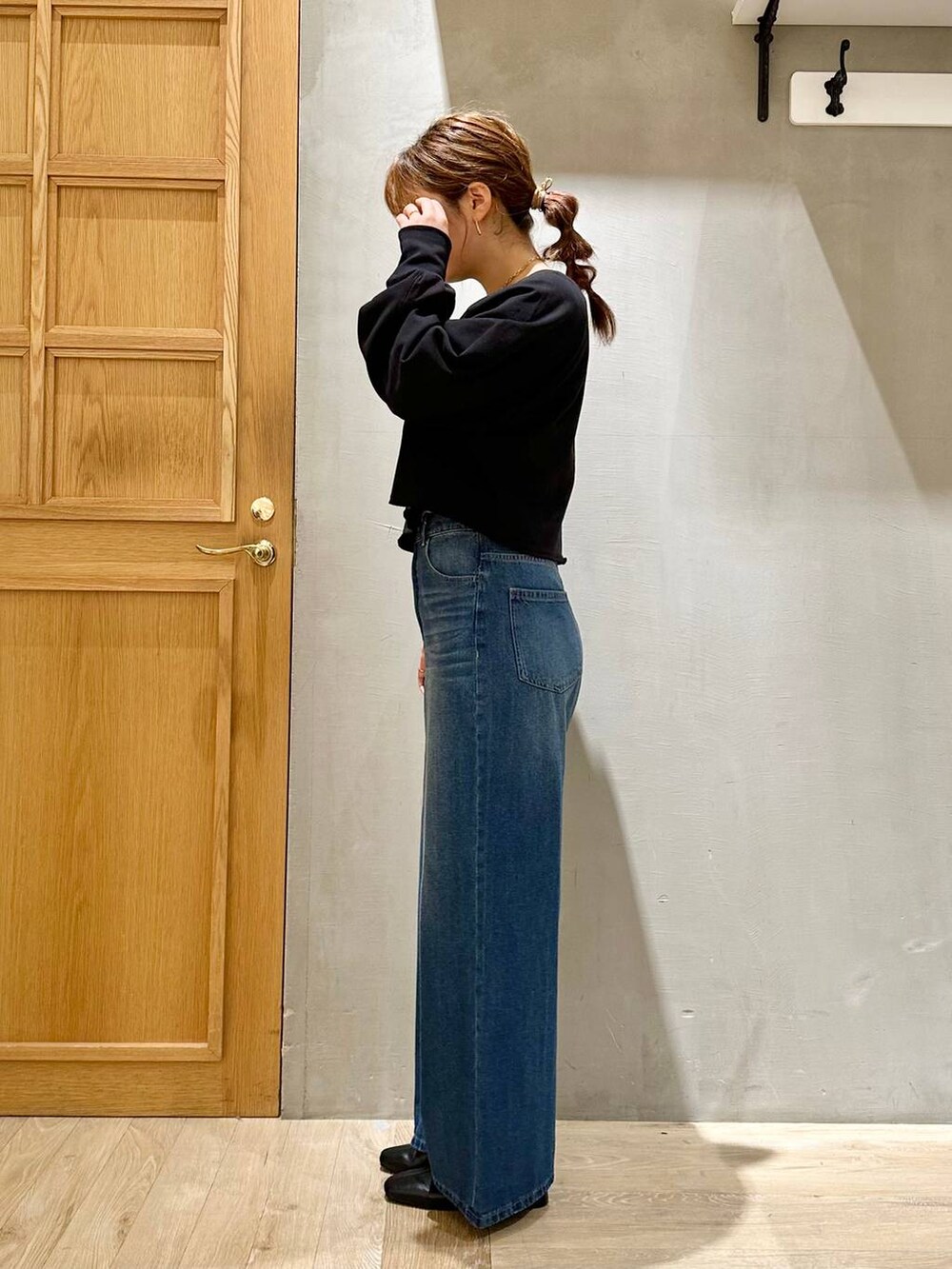 ブラック系のTシャツ/カットソー、ブルー系のデニムパンツ、ベージュ系のショルダーバッグを着用したレディースの秋コーディネートの3枚目の写真