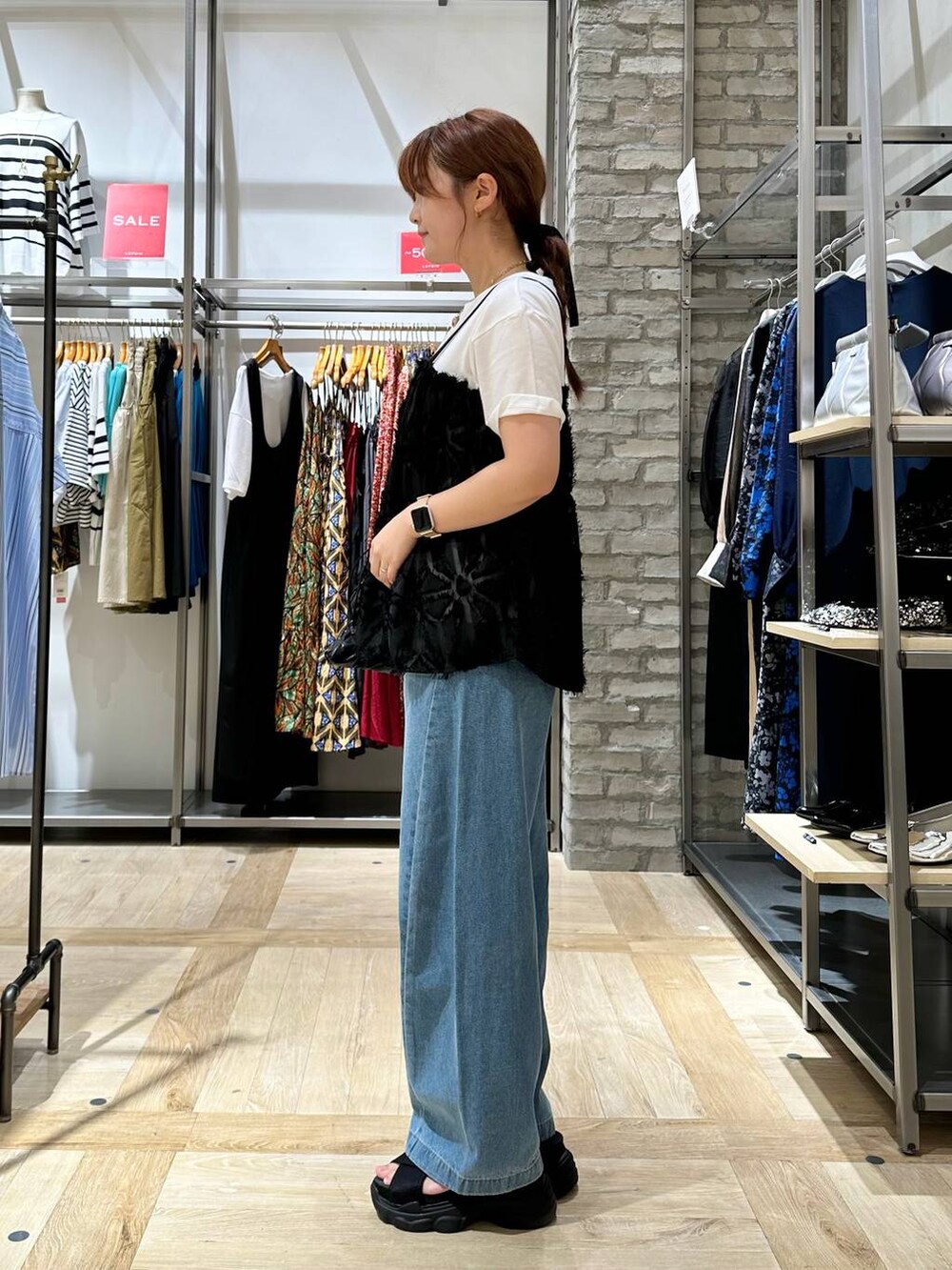 ブラック系のサンダル、ホワイト系のTシャツ/カットソー、ブラック系のショルダーバッグを着用したレディースの夏コーディネートの2枚目の写真