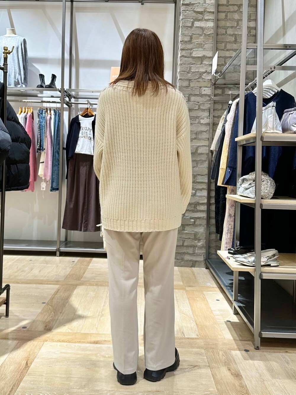 ホワイト系のボストンバッグ、ブラック系のスニーカー、ホワイト系のニット/セーターを着用したレディースの秋コーディネートの4枚目の写真