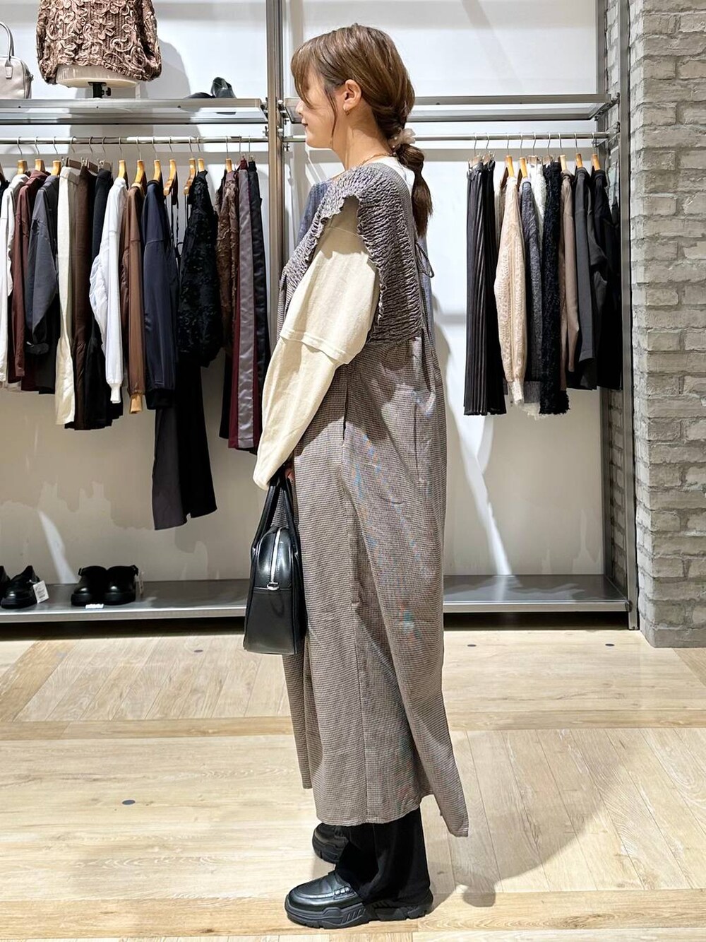ブラック系のその他パンツ、ブラック系のスニーカー、ベージュ系のTシャツ/カットソーを着用したレディースの秋コーディネートの3枚目の写真
