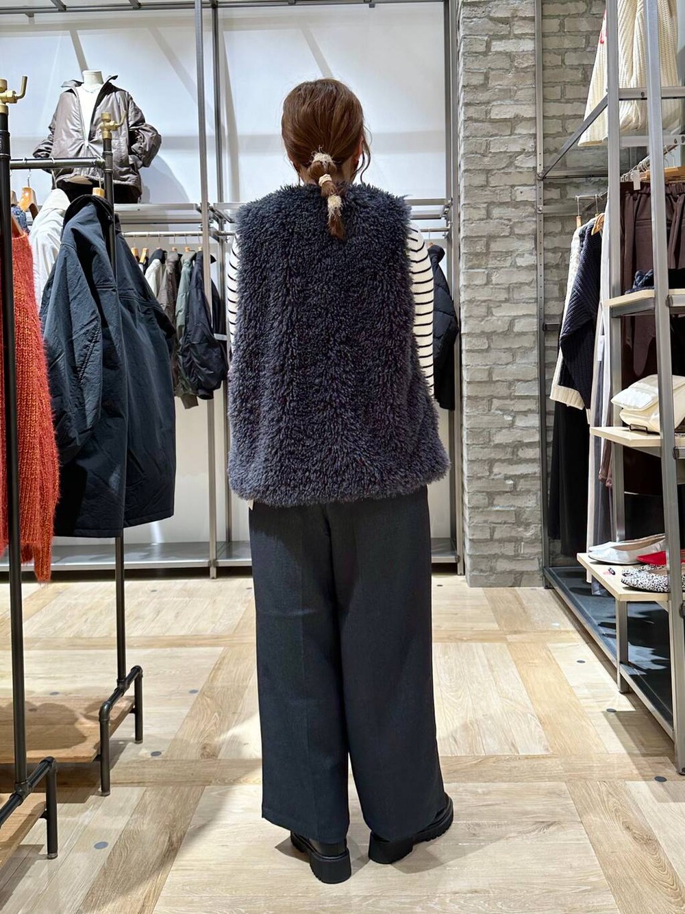 ブラック系のブーツ、ホワイト系のニット/セーター、ブラック系のショルダーバッグを着用したレディースの秋コーディネートの4枚目の写真