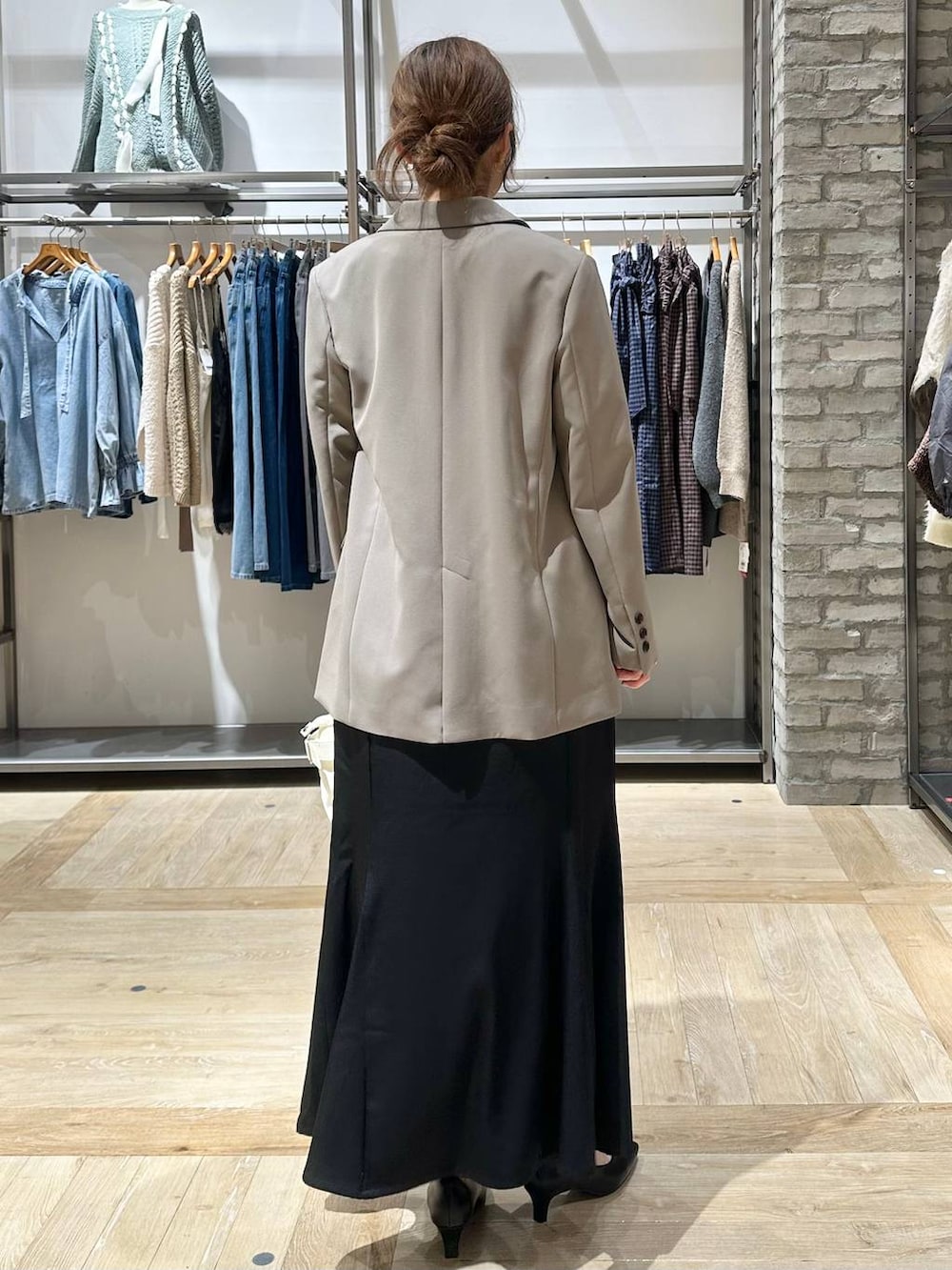 ブラウン系のテーラードジャケット、ホワイト系のTシャツ/カットソー、ブラック系のパンプスを着用したレディースの冬コーディネートの3枚目の写真