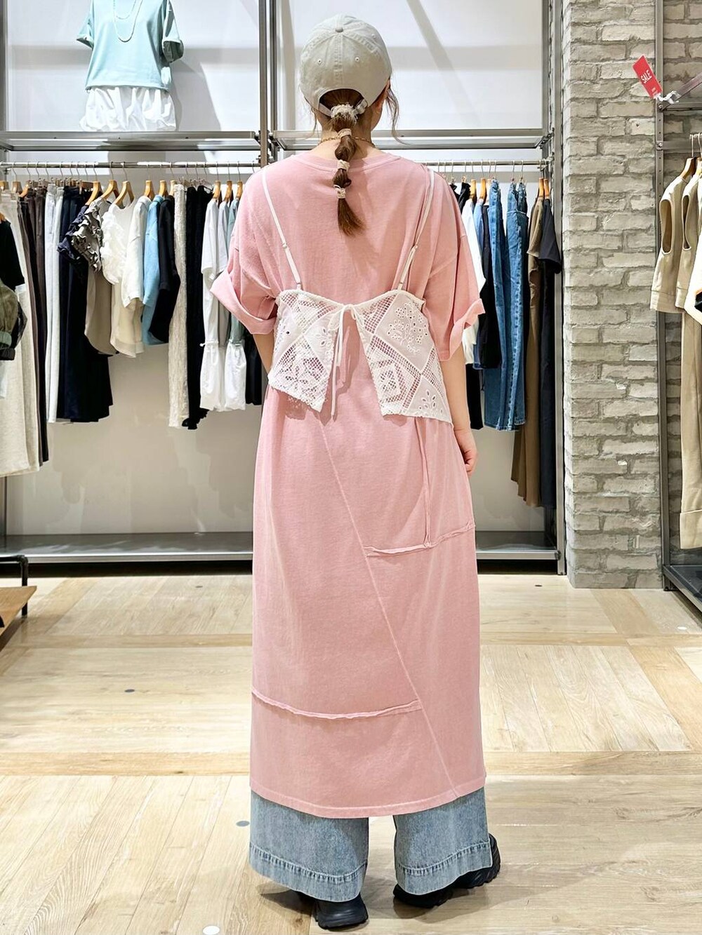 ブラック系のサンダル、ブルー系のデニムパンツ、ピンク系のトートバッグを着用したレディースの夏コーディネートの3枚目の写真