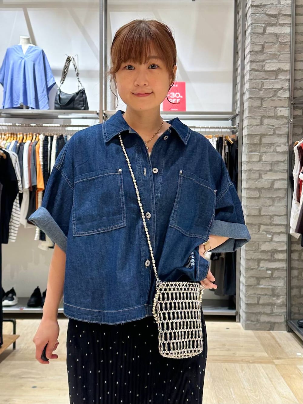 ブルー系のシャツ/ブラウス、シルバー系のショルダーバッグ、ホワイト系のタンクトップを着用したレディースの夏コーディネートの4枚目の写真