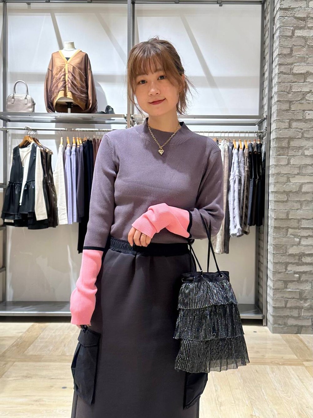 グレー系のニット/セーター、イエロー系のスニーカー、ブラック系のショルダーバッグを着用したレディースの秋コーディネートの5枚目の写真