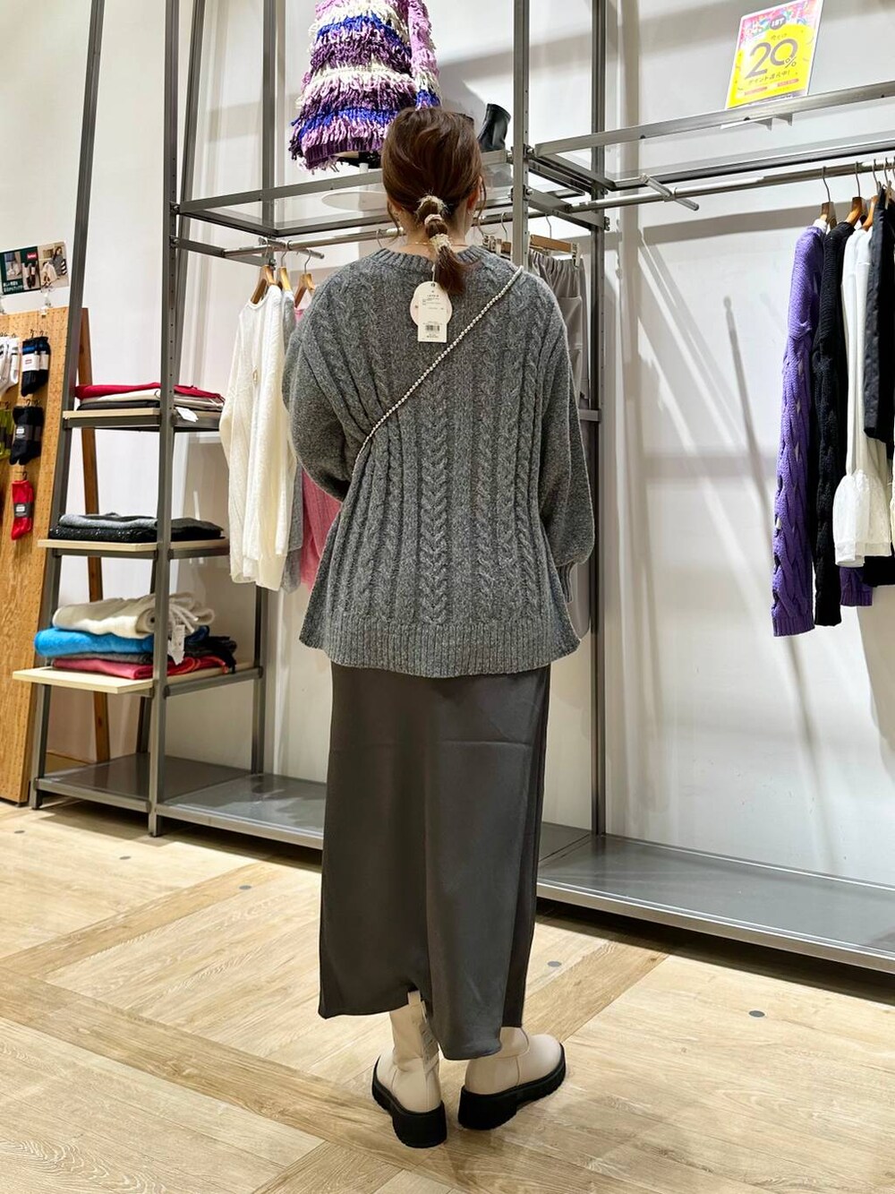 ホワイト系のブーツ、グレー系のスカート、グレー系のショルダーバッグを着用したレディースの秋コーディネートの3枚目の写真