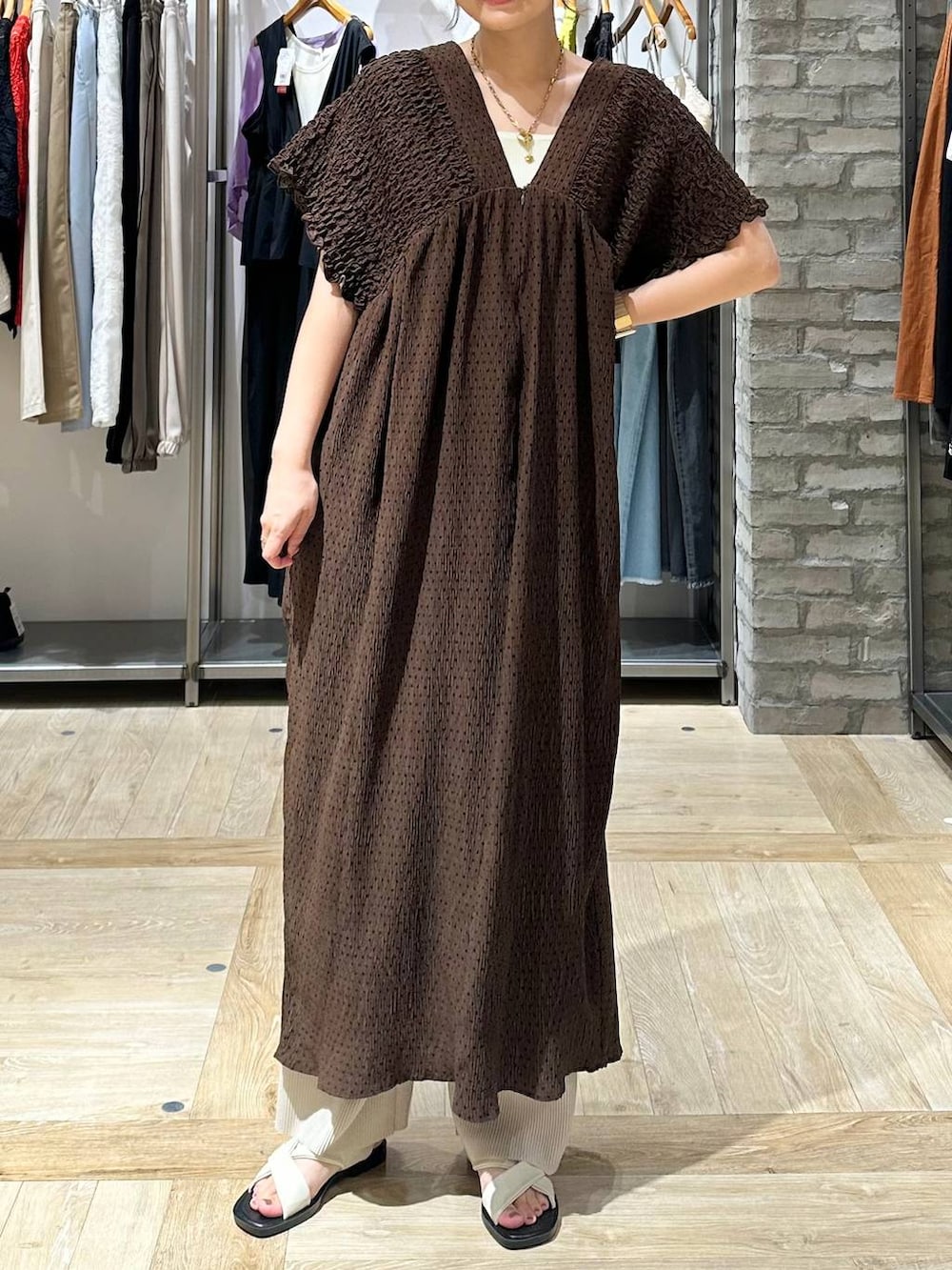 ベージュ系のその他パンツ、ホワイト系のタンクトップ、ホワイト系のサンダルを着用したレディースの夏コーディネートの5枚目の写真
