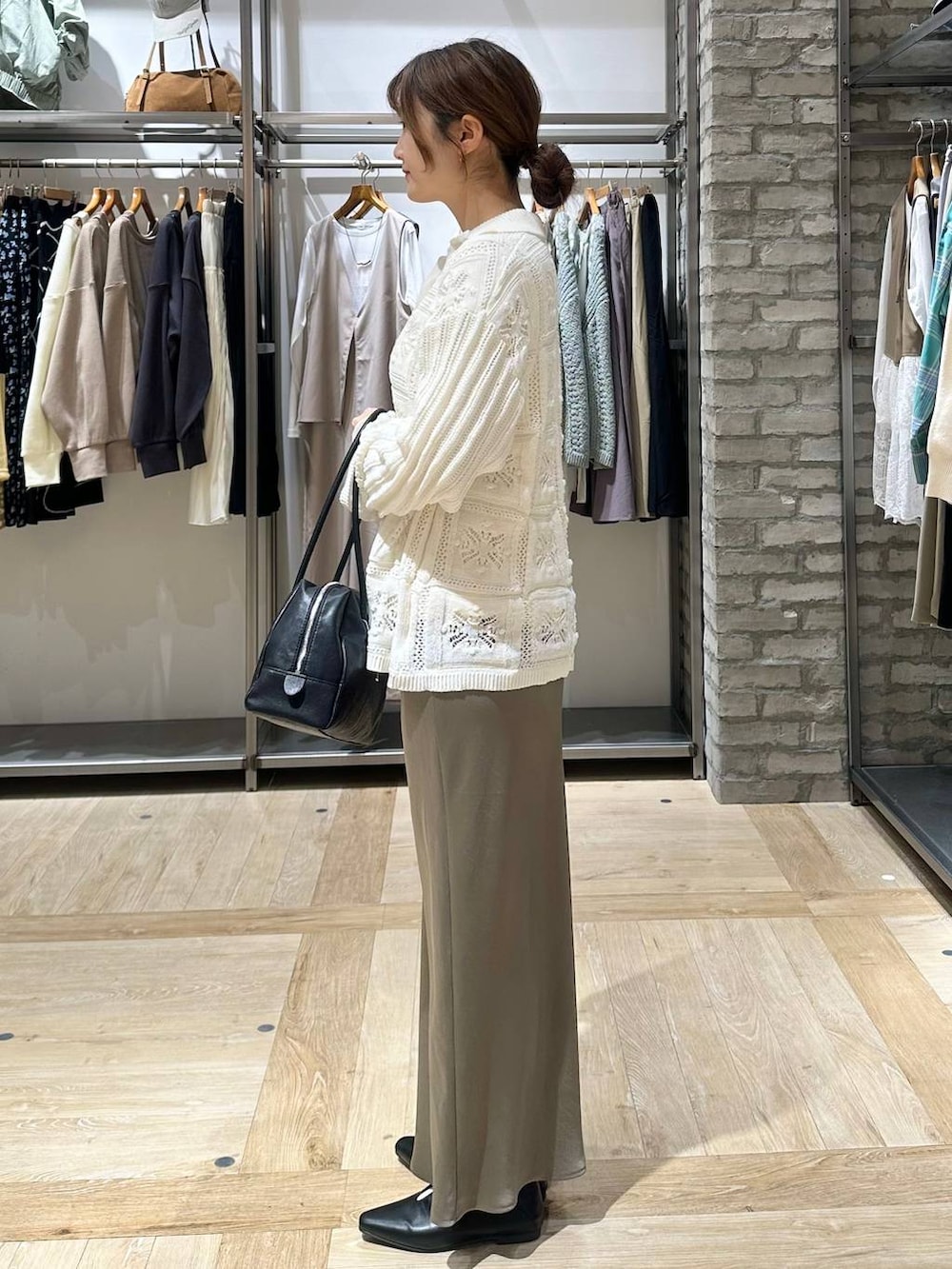 グリーン系のスカート、ホワイト系のTシャツ/カットソー、ブラック系のボストンバッグを着用したレディースの春コーディネートの2枚目の写真