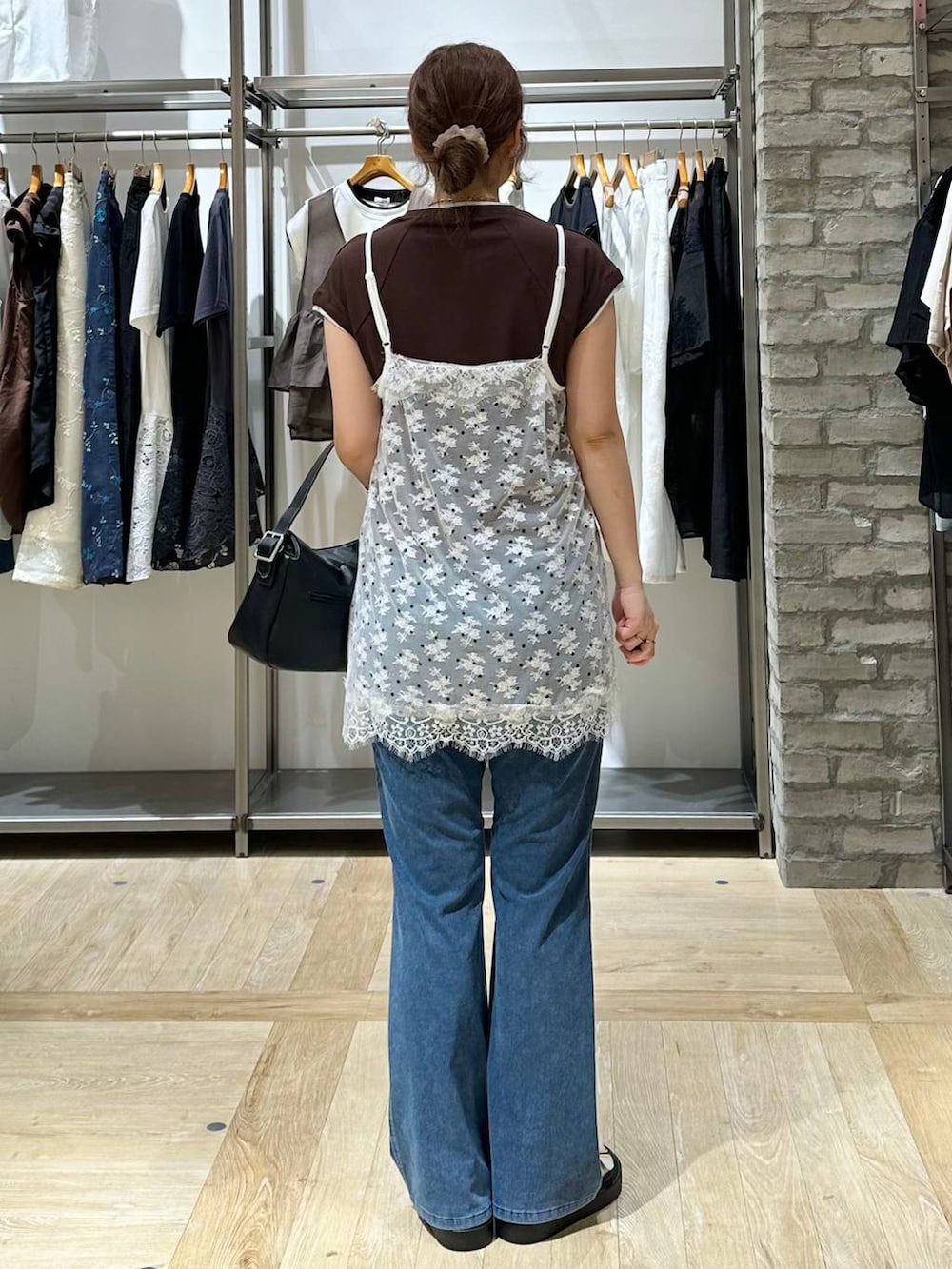 ホワイト系のサンダル、ブラック系のショルダーバッグ、ブルー系のデニムパンツを着用したレディースの夏コーディネートの3枚目の写真