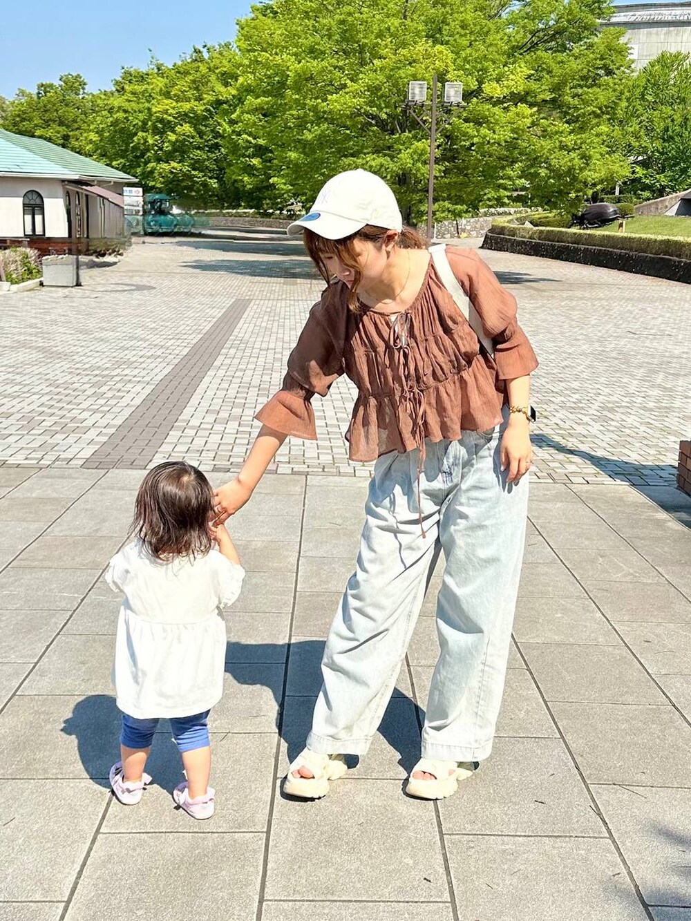 ブラウン系のシャツ/ブラウス、ブルー系のデニムパンツを着用したレディースの春コーディネートの2枚目の写真