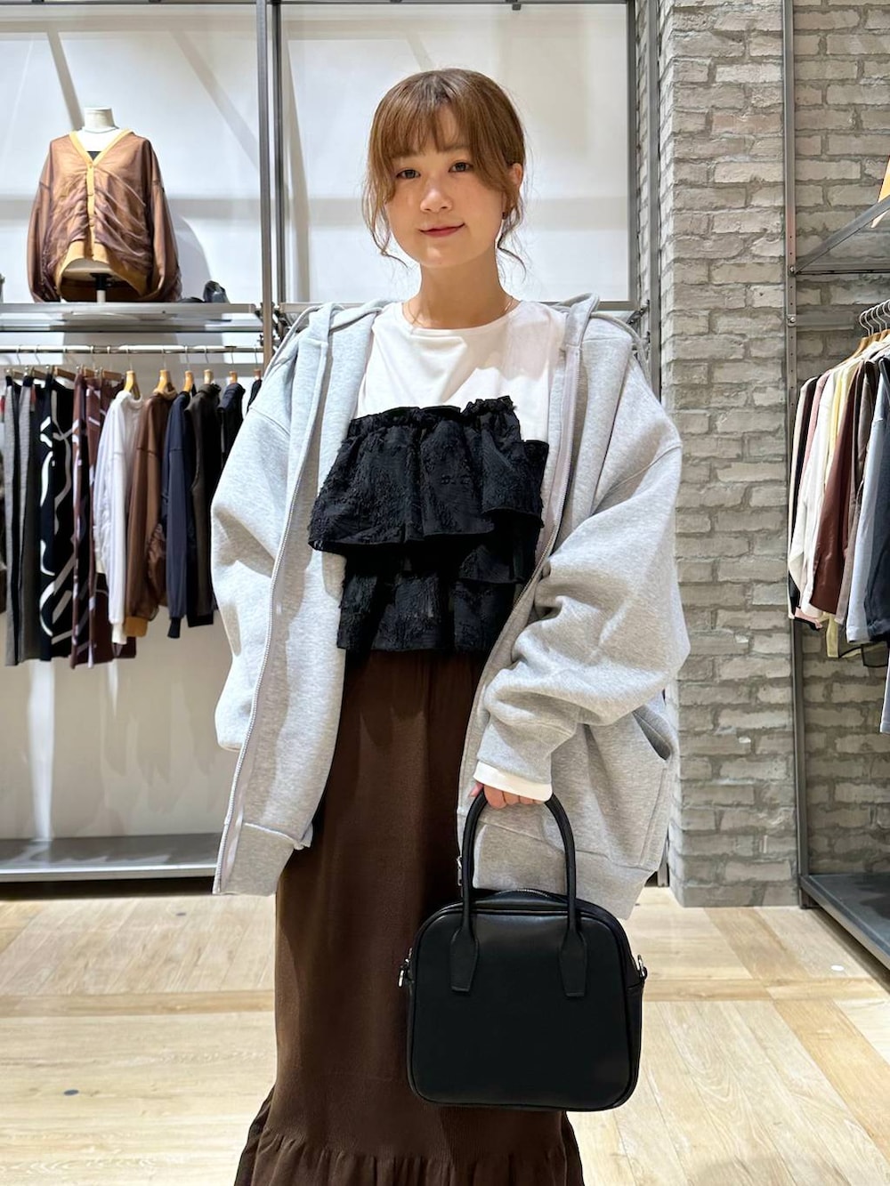 ブラウン系のスカート、ホワイト系のTシャツ/カットソー、ブラック系のサンダルを着用したレディースの秋コーディネートの5枚目の写真