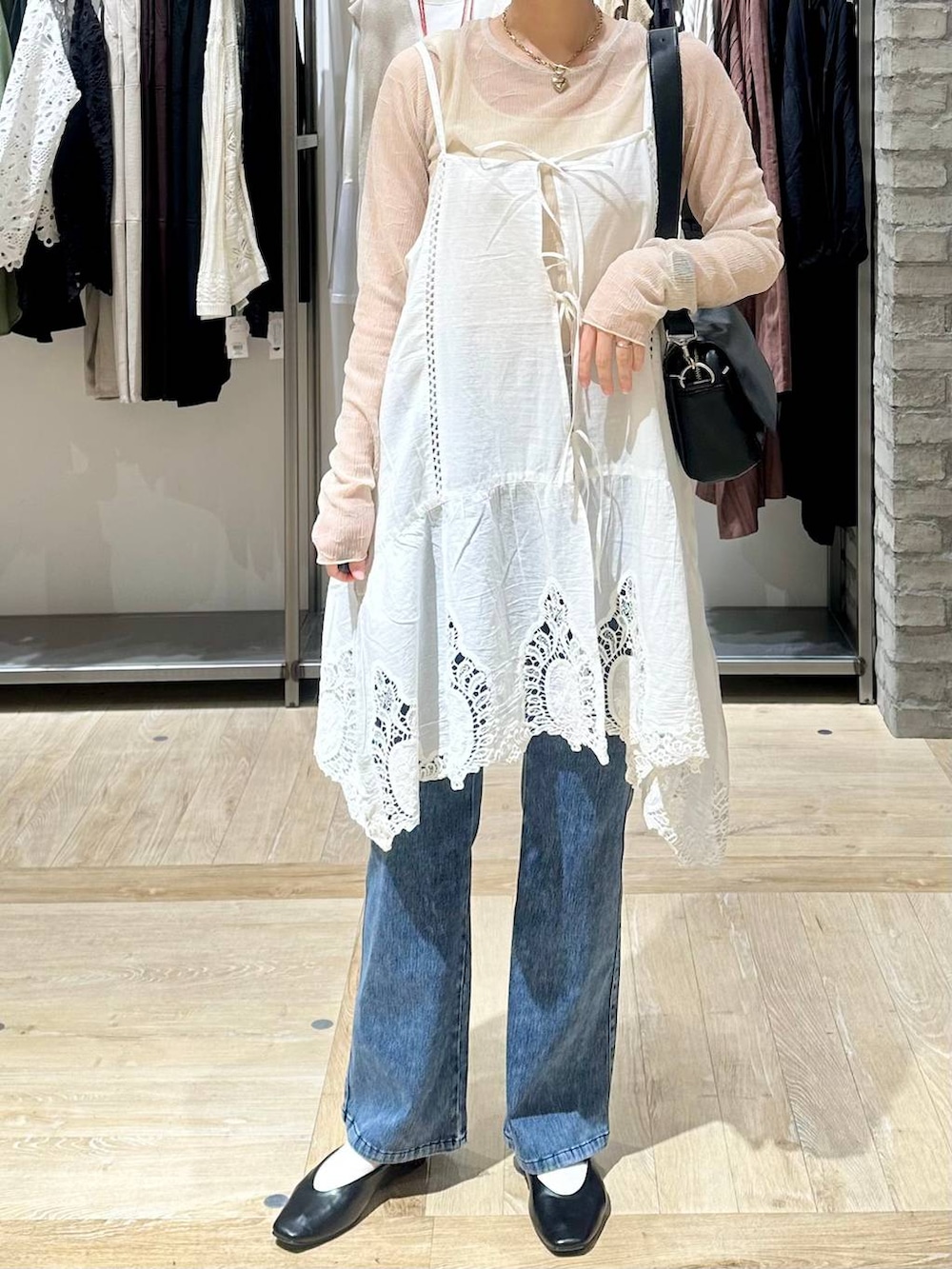 ブラック系のショルダーバッグ、ホワイト系のキャミソール、ブラック系のパンプスを着用したレディースの春コーディネートの5枚目の写真