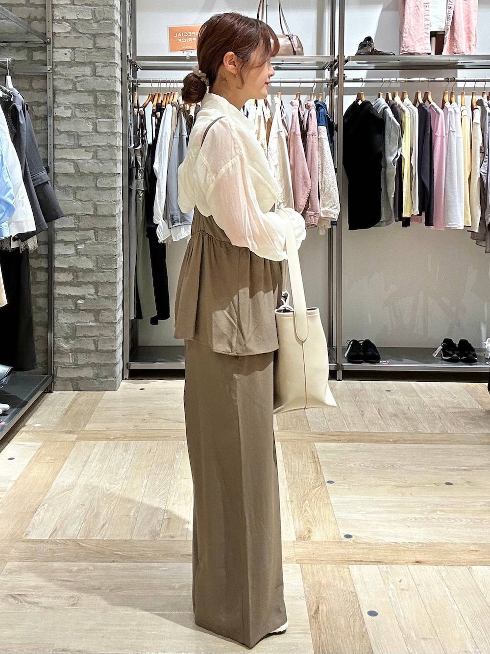 ホワイト系のシャツ/ブラウス、ホワイト系のトートバッグ、ホワイト系のパンプスを着用したレディースの春コーディネートの2枚目の写真