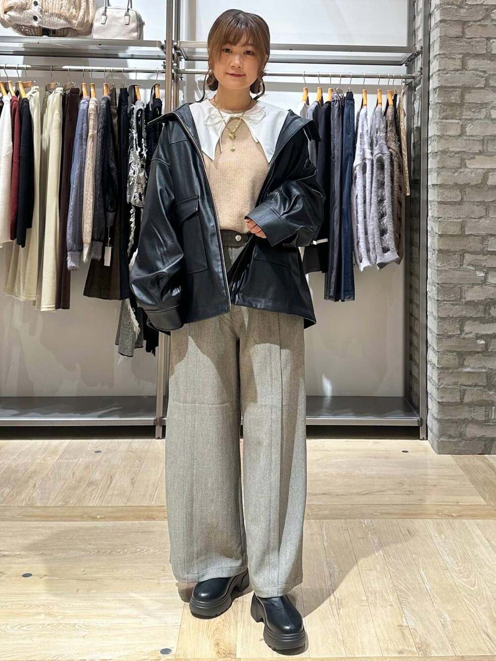 ベージュ系のニット/セーター、ブラック系のブルゾン、ブラウン系のスラックスを着用したレディースの秋コーディネートの2枚目の写真