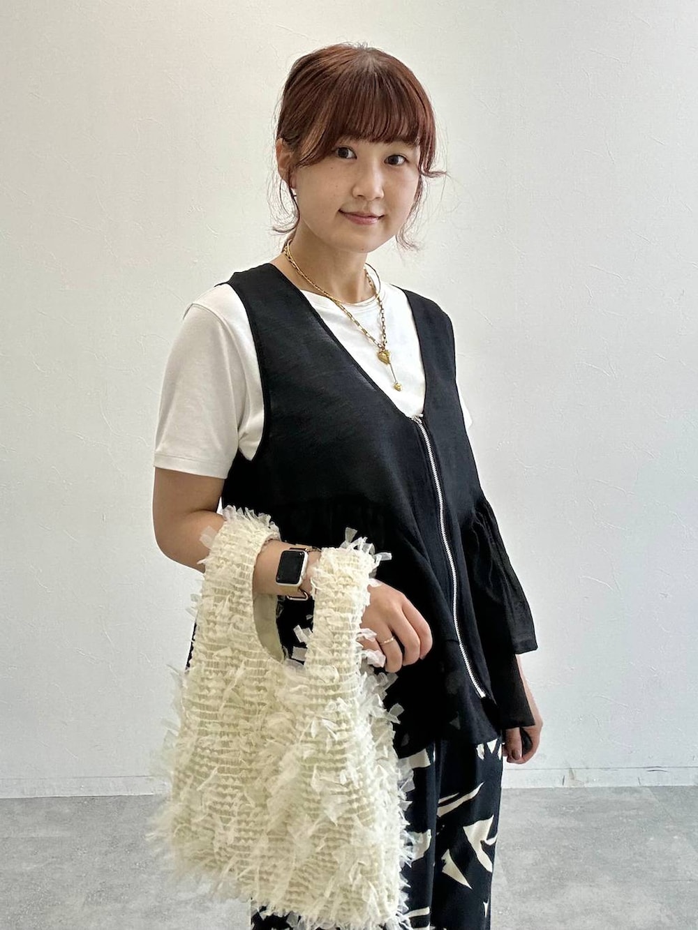 ホワイト系のTシャツ/カットソー、ブラック系のベスト、その他のサンダルを着用したレディースの夏コーディネートの4枚目の写真