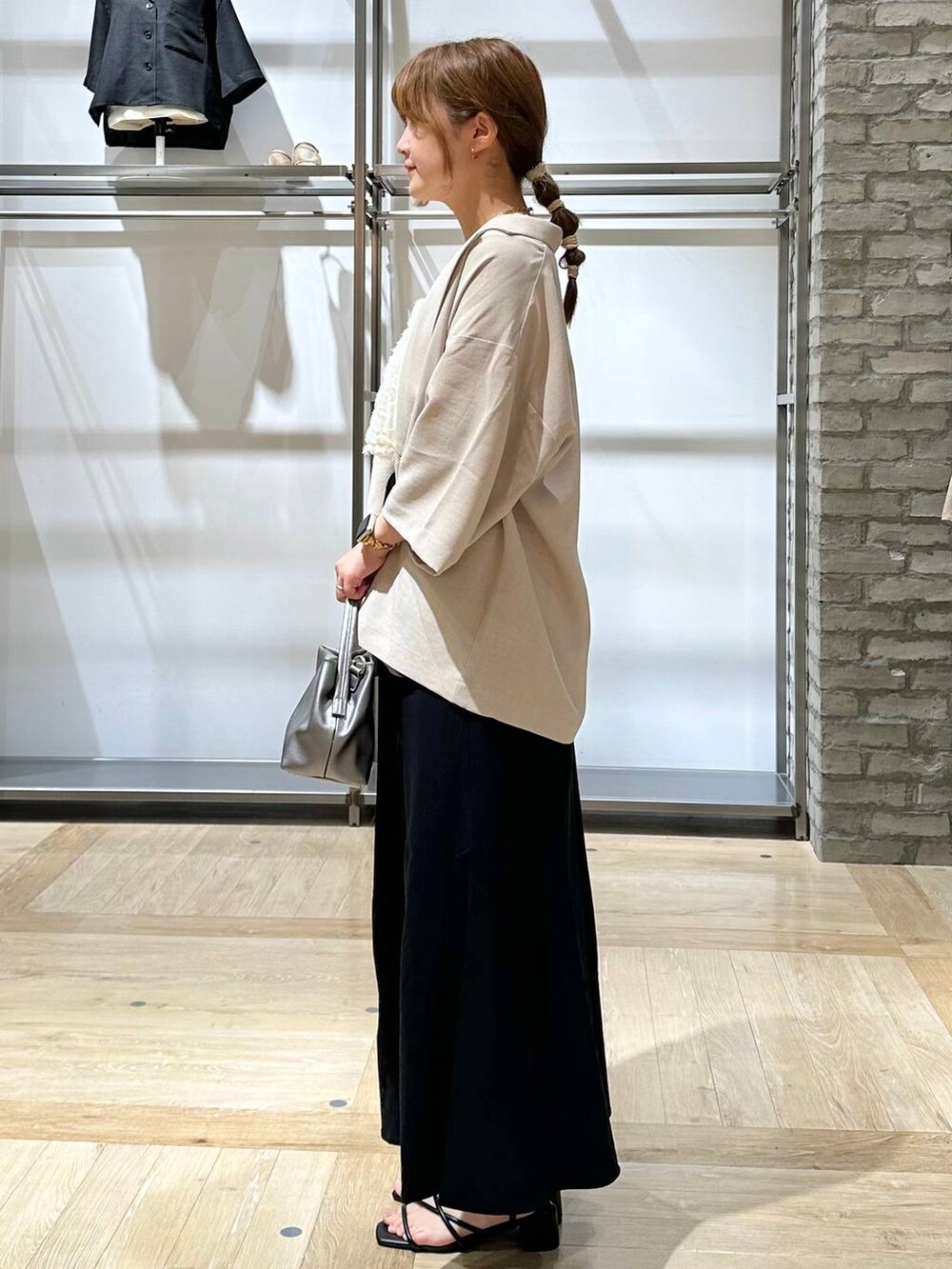 ベージュ系のテーラードジャケット、ホワイト系のタンクトップ、ブラック系のサンダルを着用したレディースの夏コーディネートの2枚目の写真